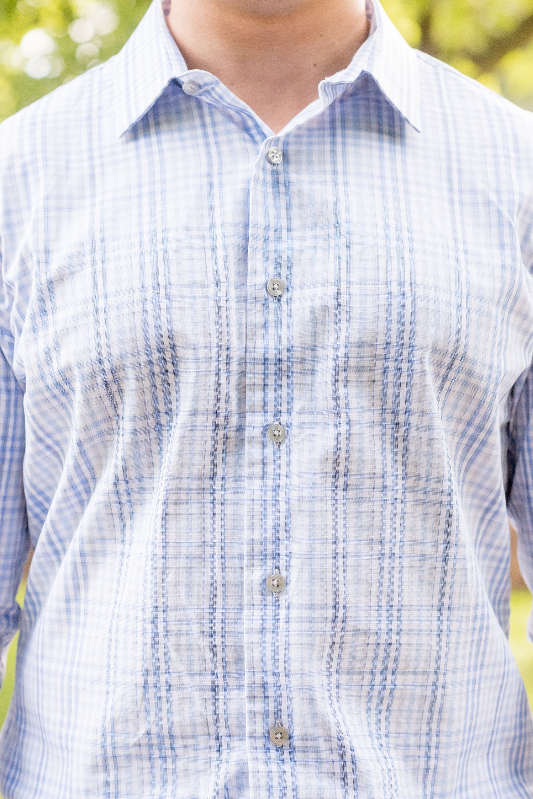 Mikkel Paige Photography photo at an Old Westbury Gardens engagement session on Long Island with the groom in a light blue plaid button down shirt and khaki pants.