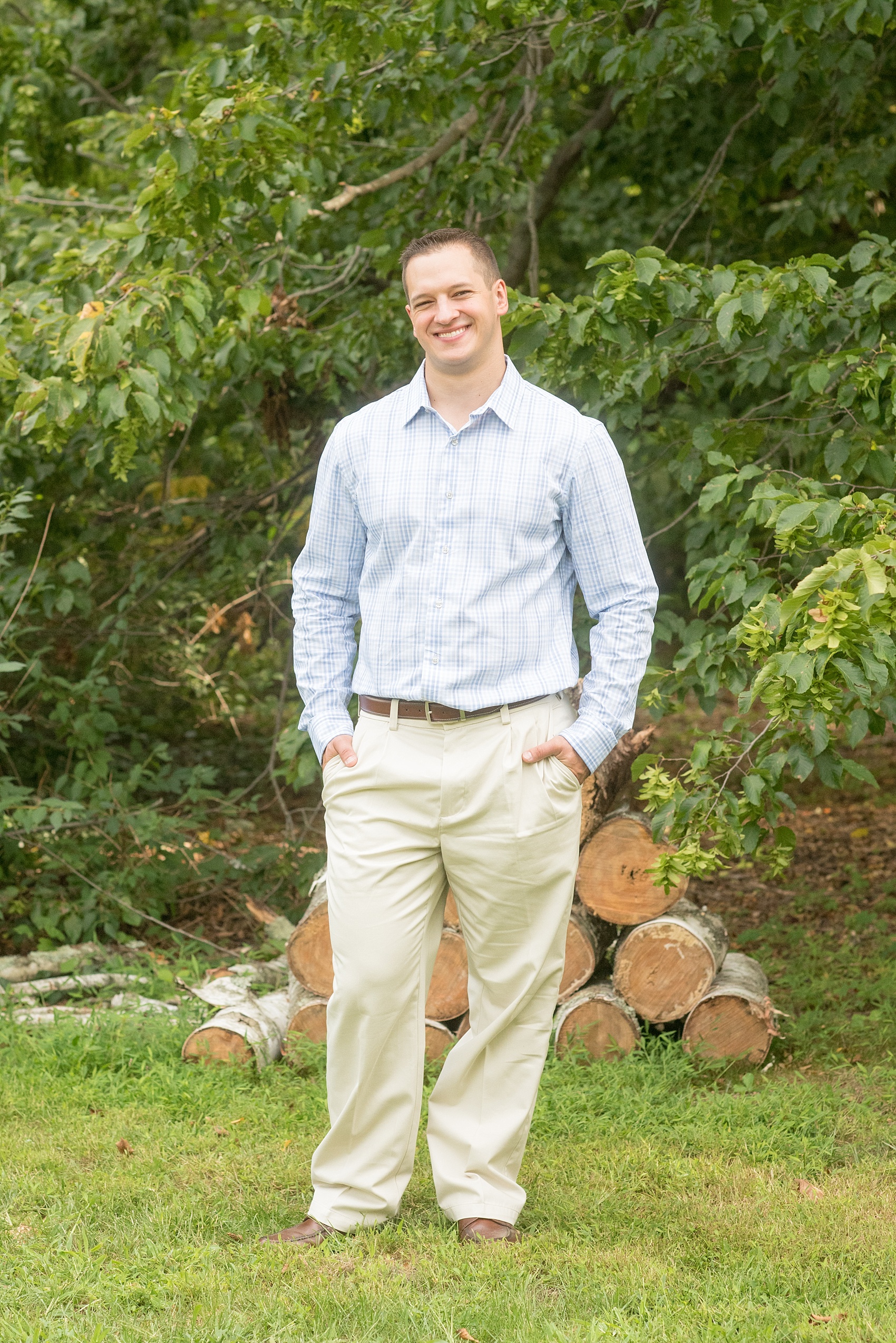 Mikkel Paige Photography photo at an Old Westbury Gardens engagement session on Long Island with the groom in a light blue plaid button down shirt and khaki pants.