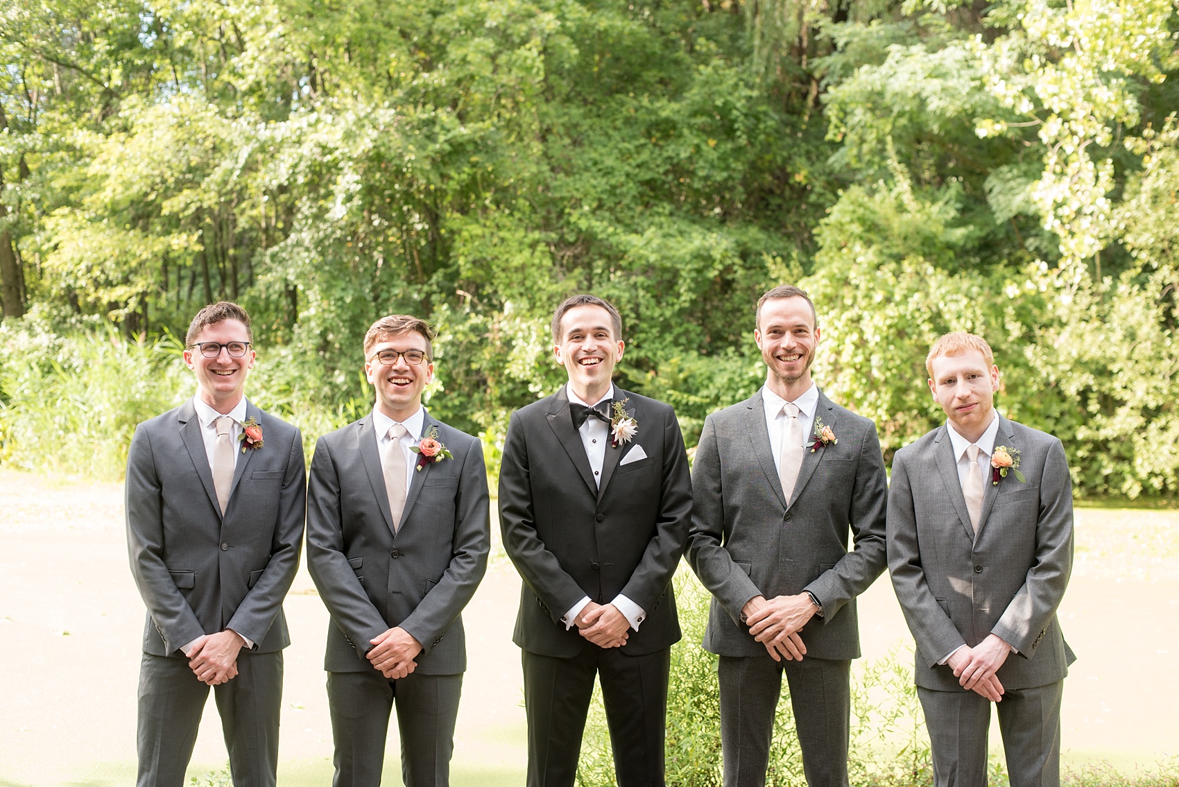 Mikkel Paige Photography photos from a wedding at Prospect Park Boathouse in Brooklyn, NY. Groomsmen in grey suits with ranunculus boutonnieres. 