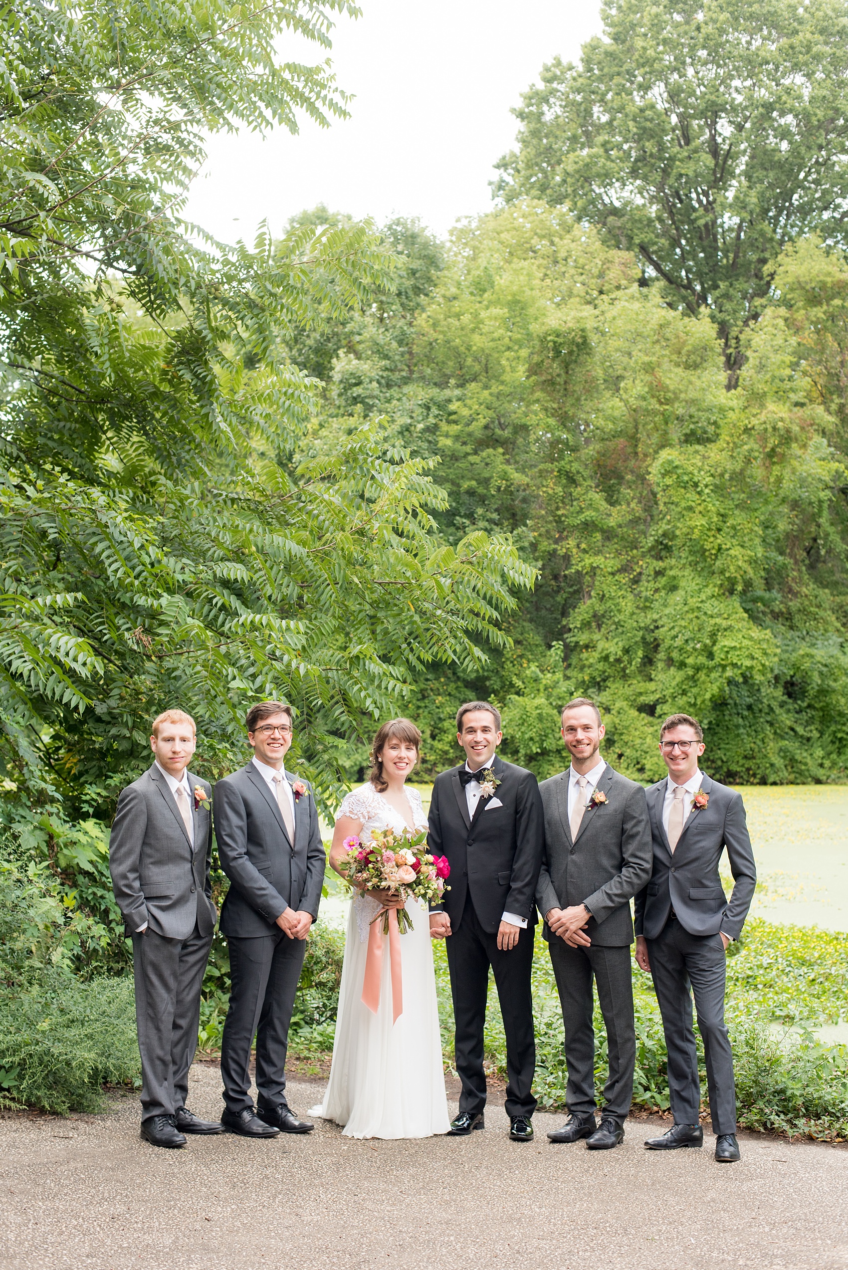 Mikkel Paige Photography photos from a wedding at Prospect Park Boathouse in Brooklyn, NY. Groomsmen in grey suits with ranunculus boutonnieres. 