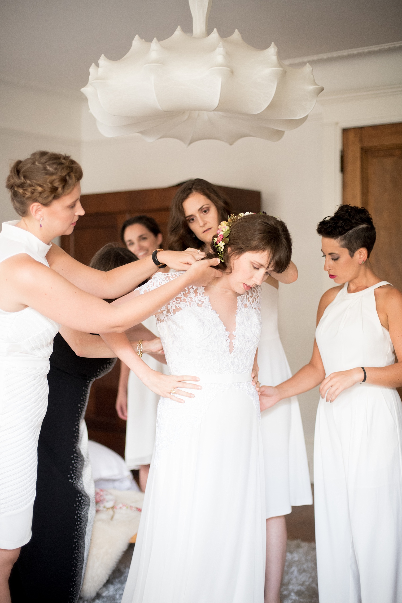 Mikkel Paige Photography photos of a wedding at Prospect Park Boathouse in Brooklyn, NY. The bride gets dressed with her bridesmaids in her white Reem Acra gown.