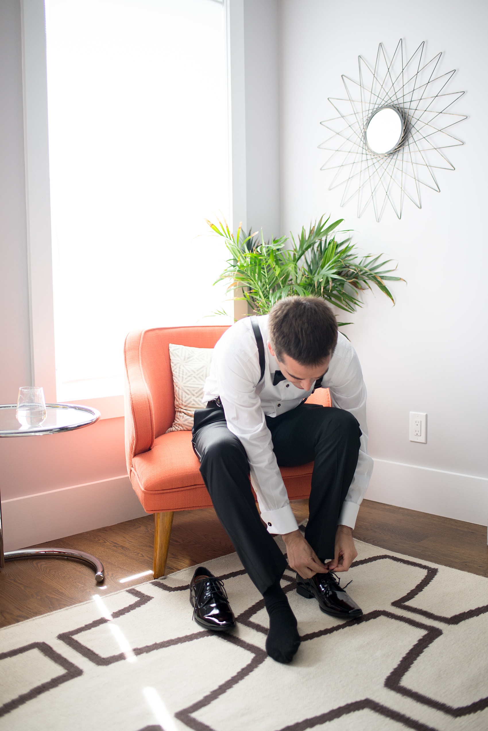 Mikkel Paige Photography photos of a wedding at Prospect Park Boathouse in Brooklyn, NY. A photo of the groom preparing for his day in a mod Air BnB in NYC.