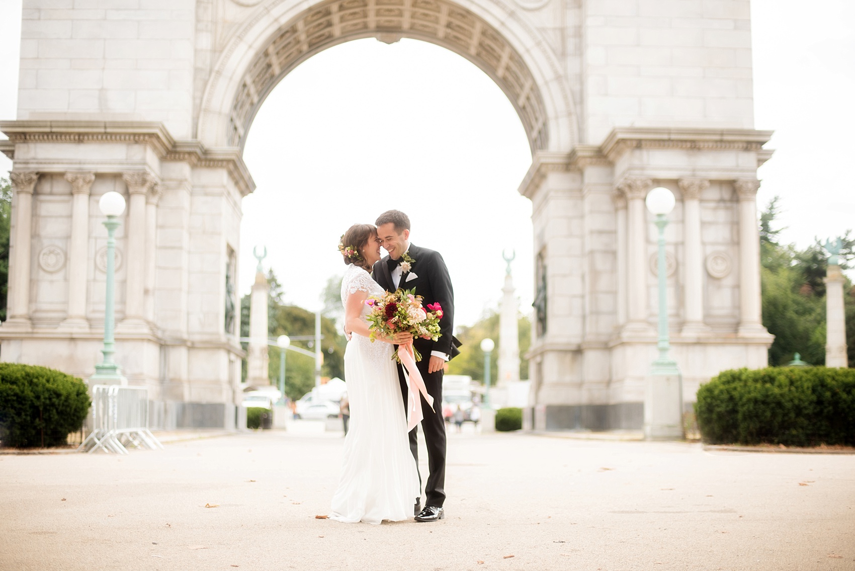 Mikkel Paige Photography photos of a wedding first look at Grand Army Plaza for a Prospect Park Boathouse ceremony in Brooklyn, NY. The bride and groom have a candid moment under the arch.