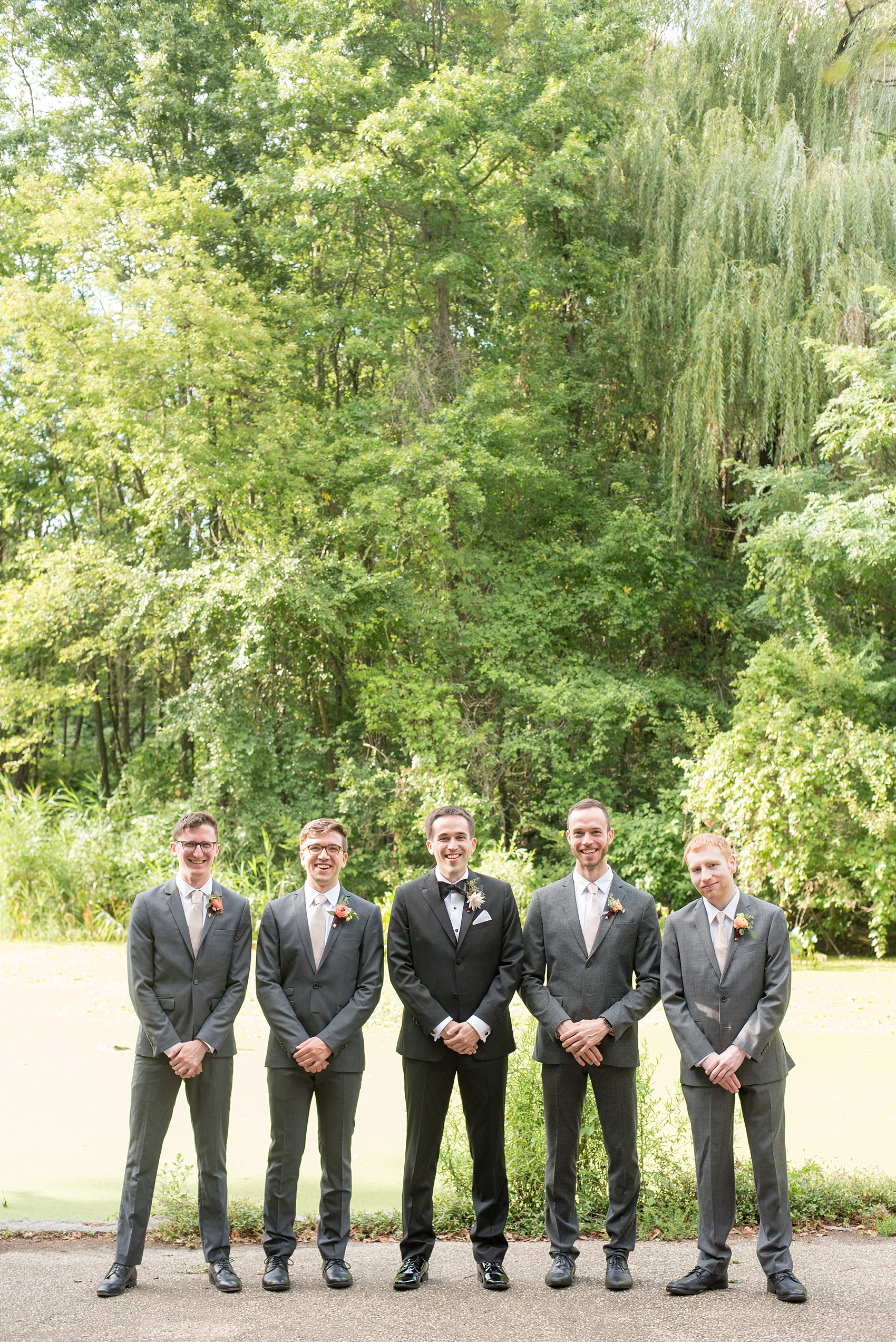 Mikkel Paige Photography photos of a wedding at Prospect Park Boathouse ceremony in Brooklyn, NY. The bride wore a classic black tuxedo and bow tie and groomsmen wore grey suits.