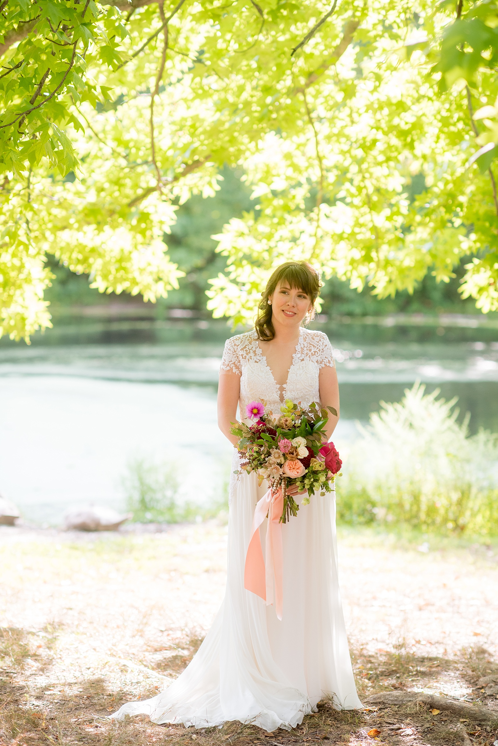 Mikkel Paige Photography photos of a bride in her Reem Acra gown for her wedding at Prospect Park Boathouse in Brooklyn, NY. Flowers by Sachi Rose design including pinks and peaches.