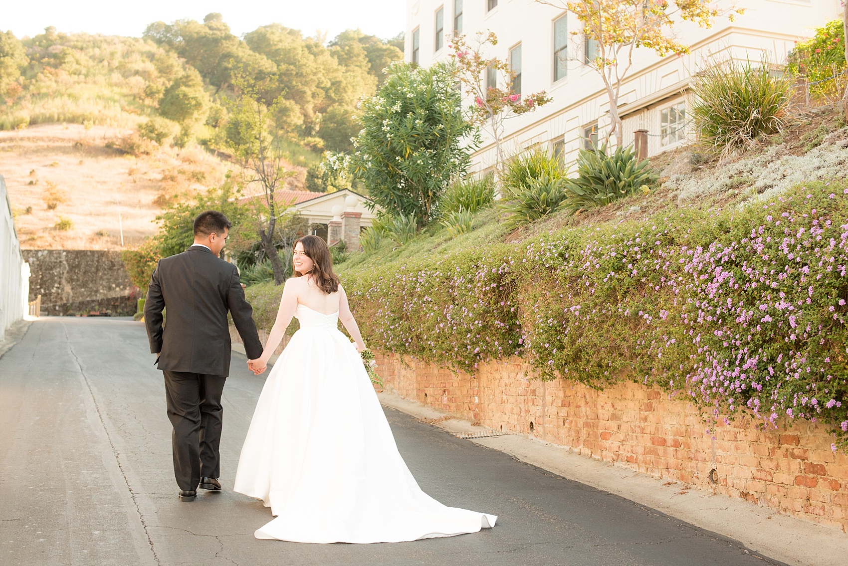 Mikkel Paige Photography photo of the bride and groom at their wedding at Testarossa Winery in Los Gatos, California with a purple flower wall.