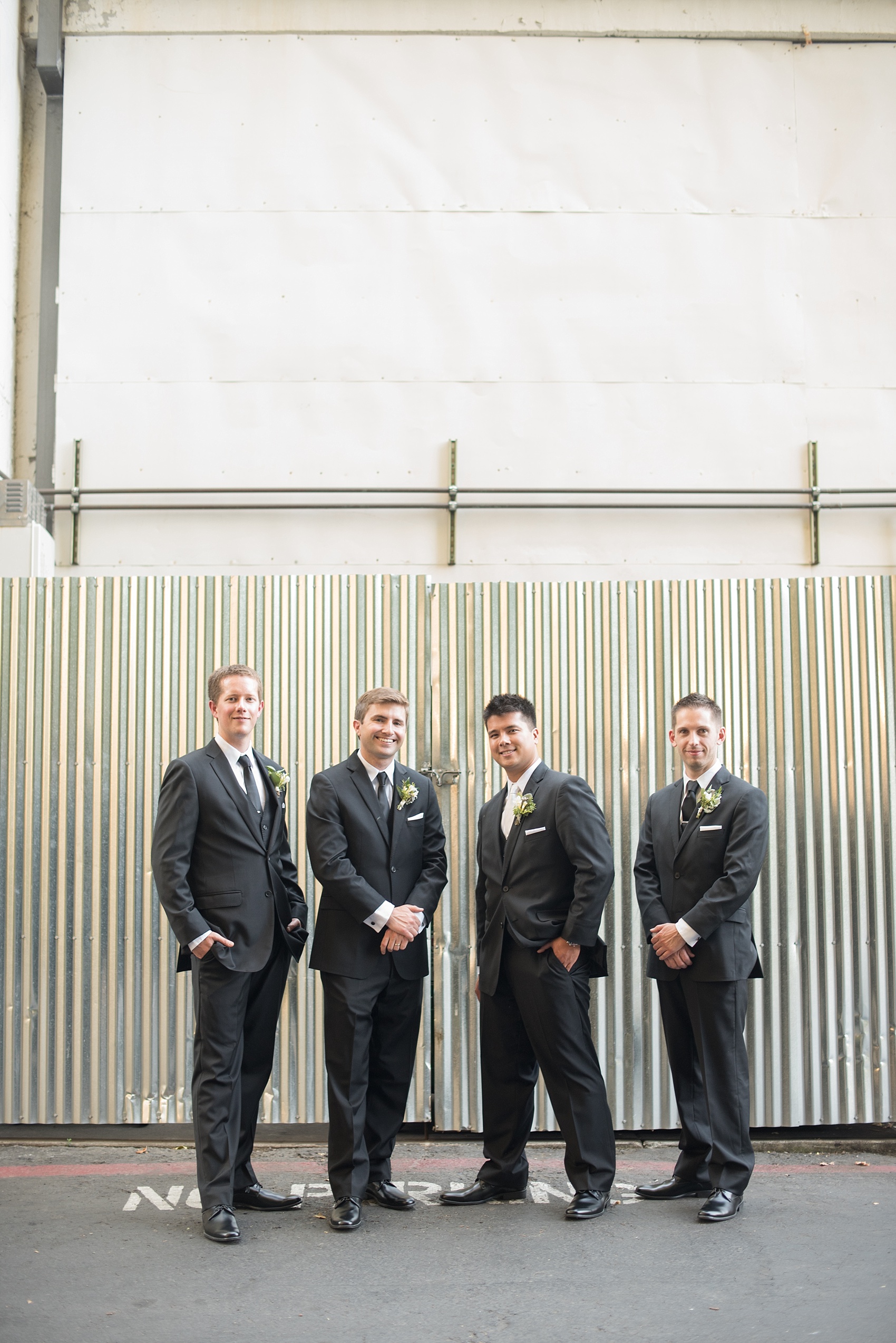 Mikkel Paige Photography photo of the groom and his groomsmen in front of an urban backdrop at his wedding at Testarossa Winery in Los Gatos, California.