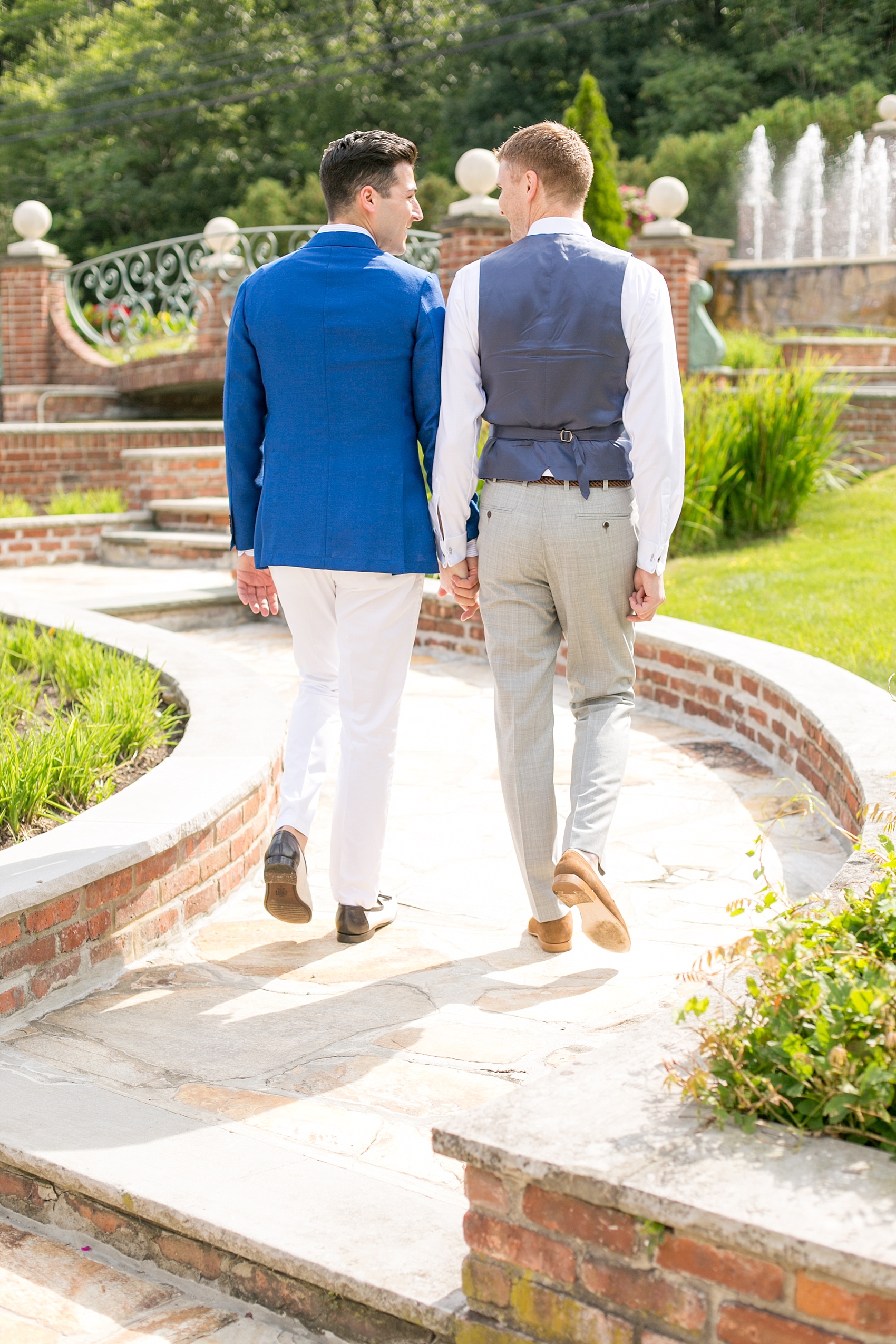 Mikkel Paige Photography photos of a summer, daytime gay wedding. An image of the grooms walking at their venue, The Manor, in West Orange New Jersey.