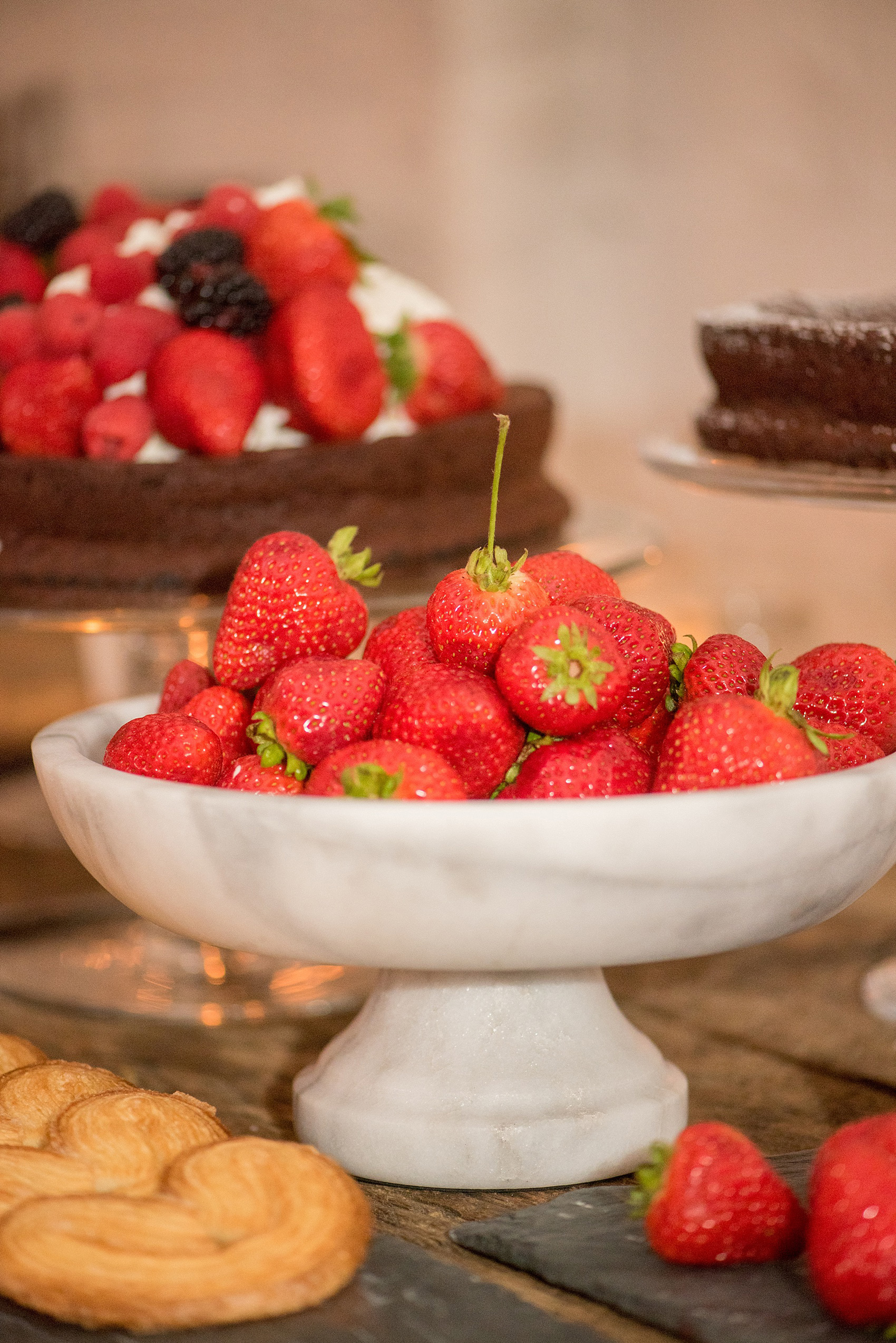 Mikkel Paige Photography photos of a wedding rehearsal dinner at Aterlier Roquette, Brooklyn. A romantic intimate setting for a small gathering in a warehouse district. Dessert was presented on a farm table, with fresh strawberries and flourless chocolate cake.