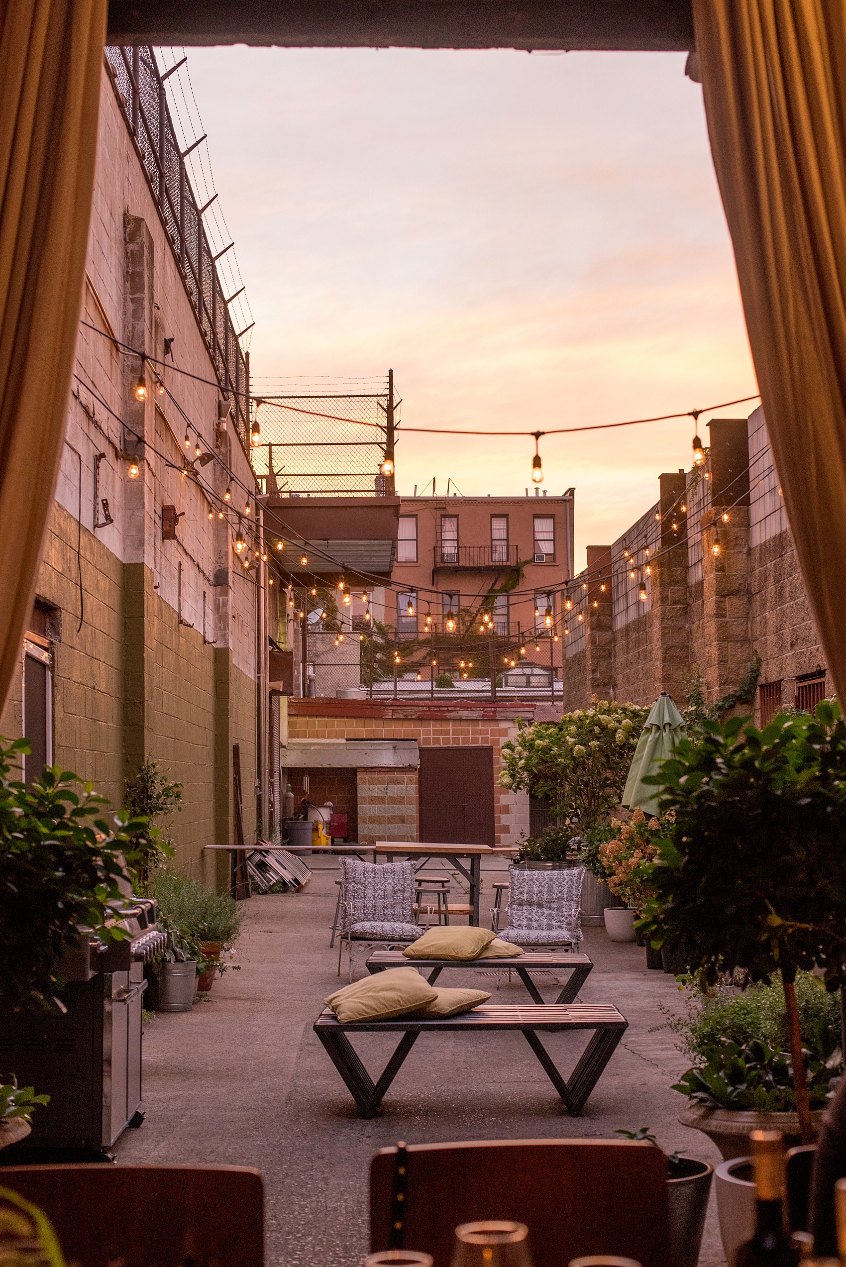 Mikkel Paige Photography photos of a wedding rehearsal dinner at Aterlier Roquette, Brooklyn. A romantic intimate setting for a small gathering in a warehouse district with an outside courtyard and bistro lights.