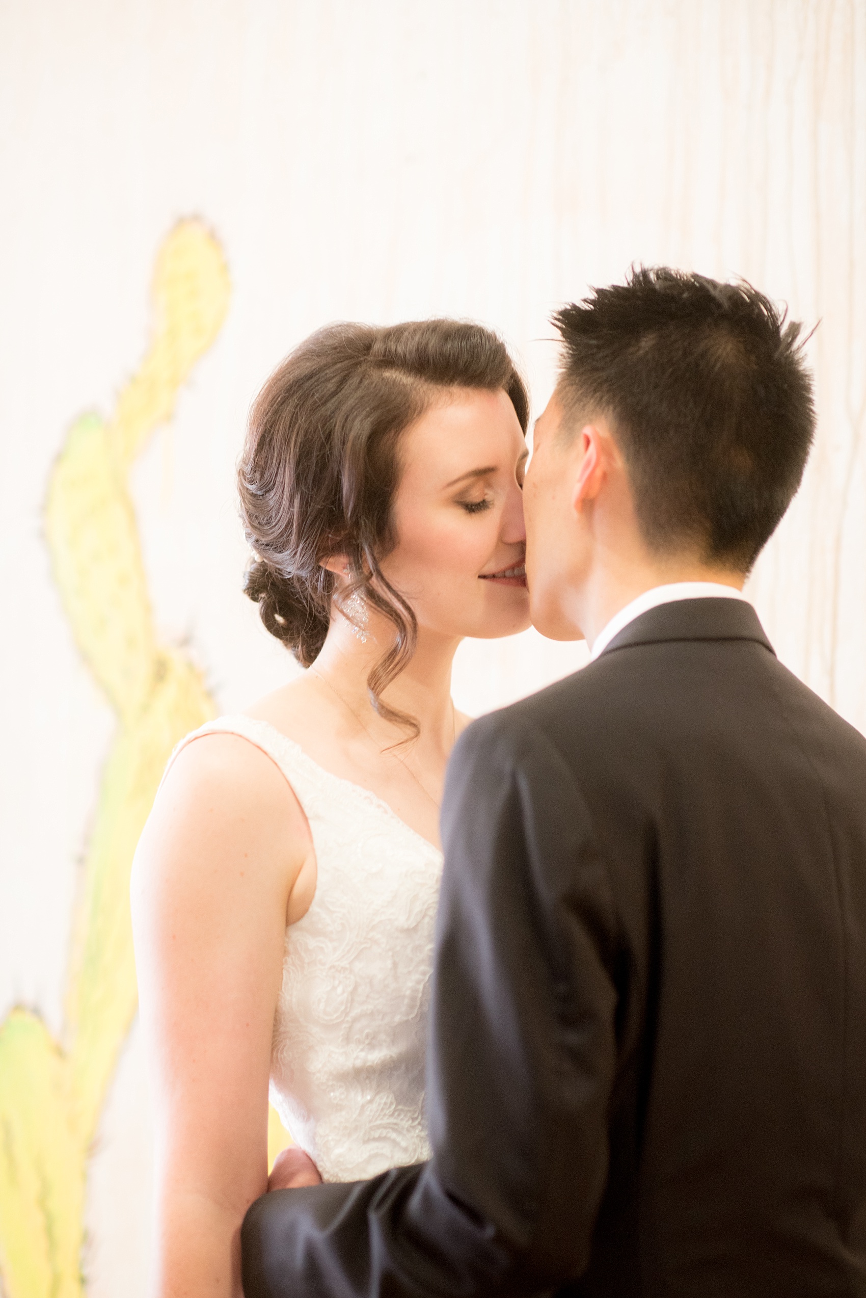 Mikkel Paige Photography photos of a wedding in downtown Raleigh. The bride and groom kiss after their first look. 