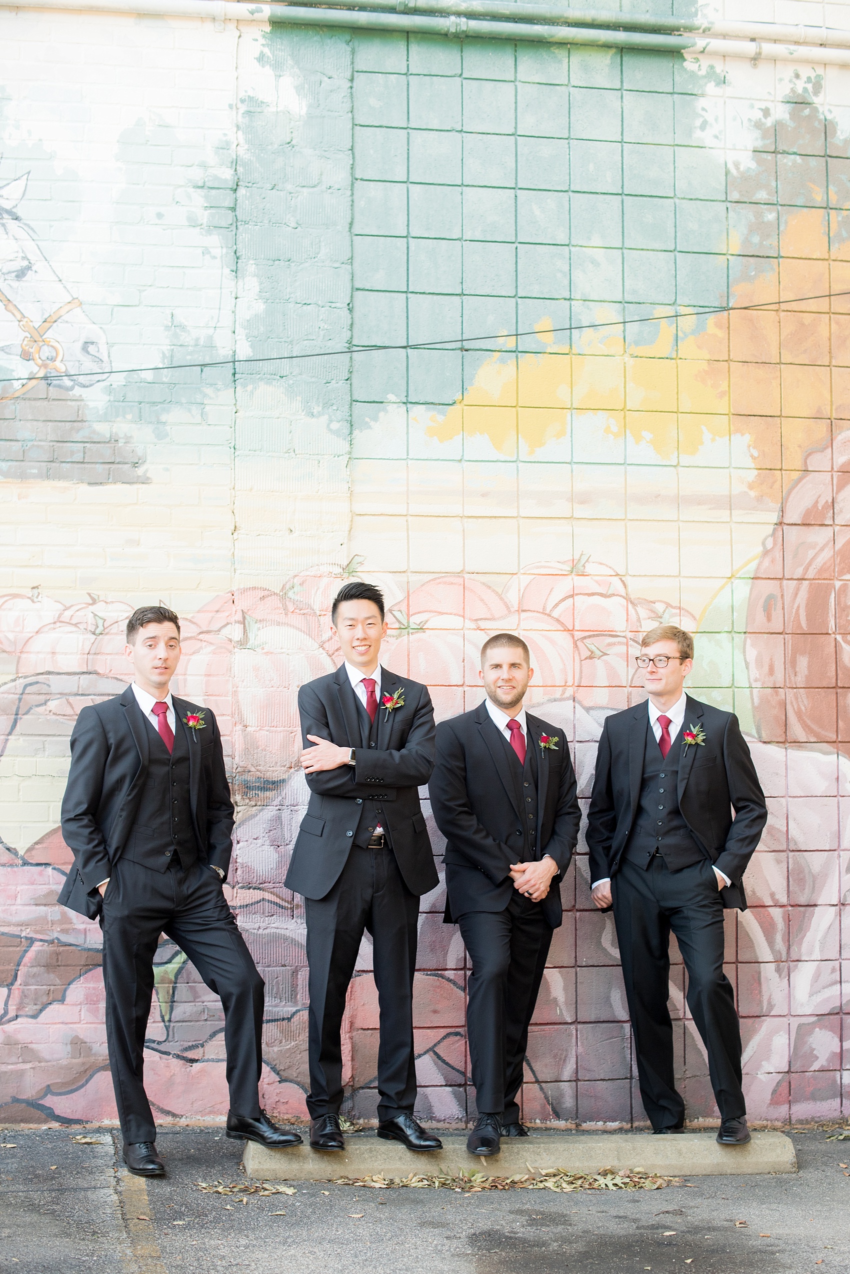 Mikkel Paige Photography photos of a wedding in downtown Raleigh. An image of the groomsmen in front of a colorful street art mural.