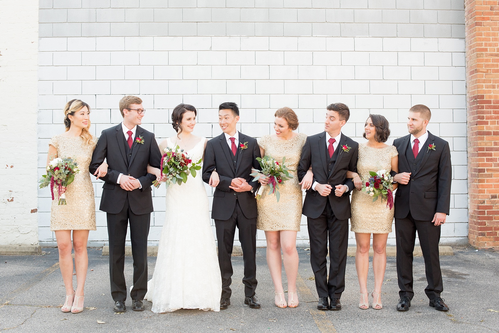 Mikkel Paige Photography photos of a wedding in downtown Raleigh. An image of the wedding party and bridesmaids in short gold dresses holding fall bouquets.