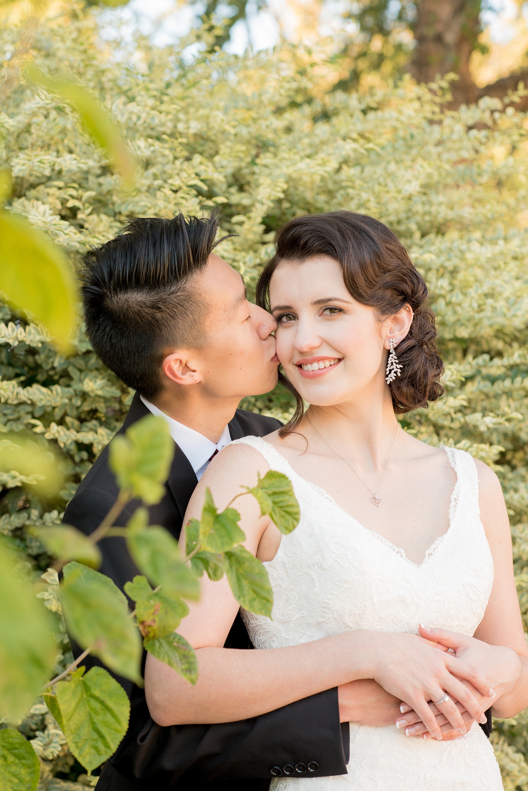 Mikkel Paige Photography photos of a wedding in downtown Raleigh. The groom gives the bride a sweet kiss on the cheek!