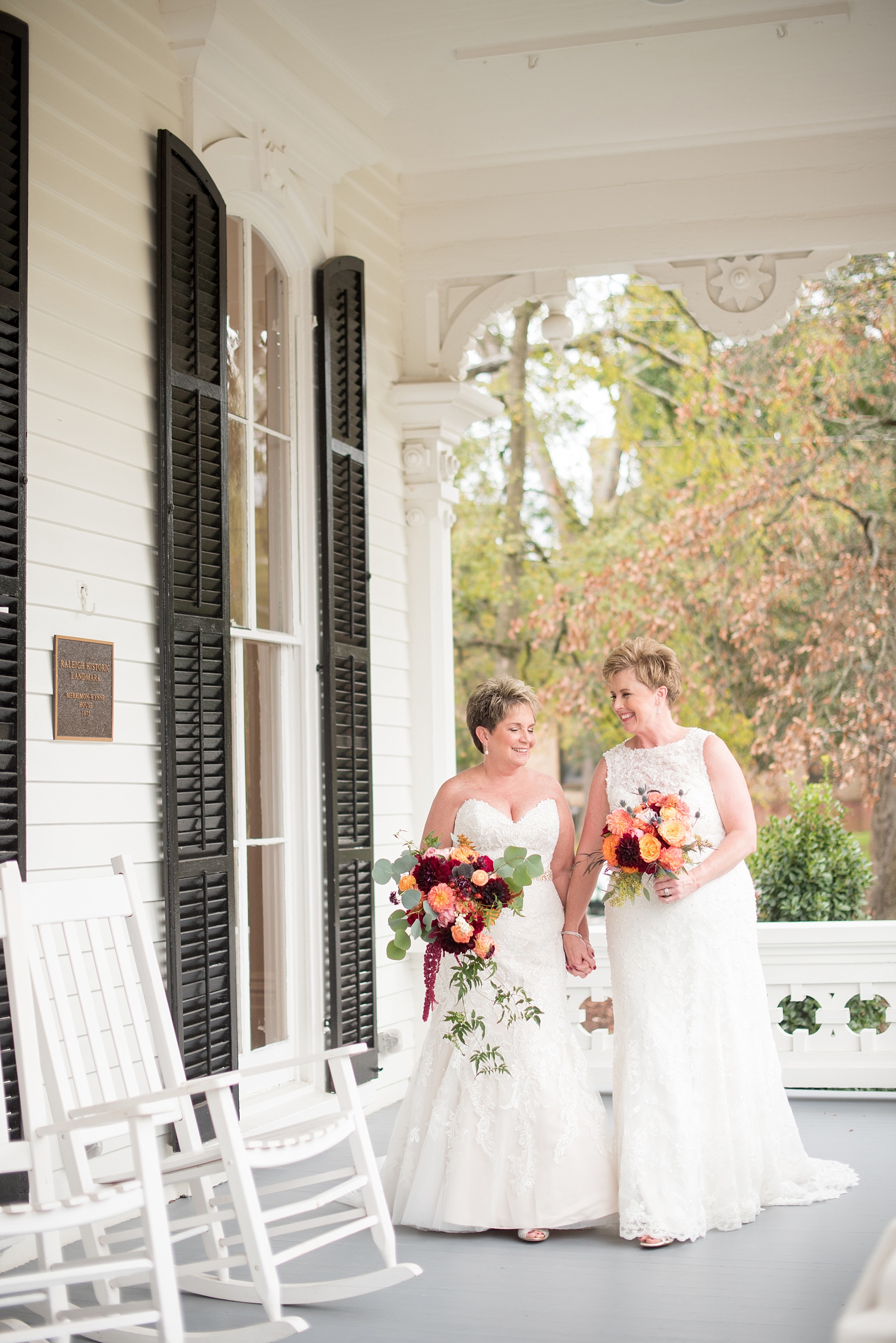 Mikkel Paige Photography photos from a Merrimon-Wynne House wedding in Raleigh. Two brides tie the knot during their same-sex fall wedding. Pictures on the porch of the beautiful southern mansion venue.