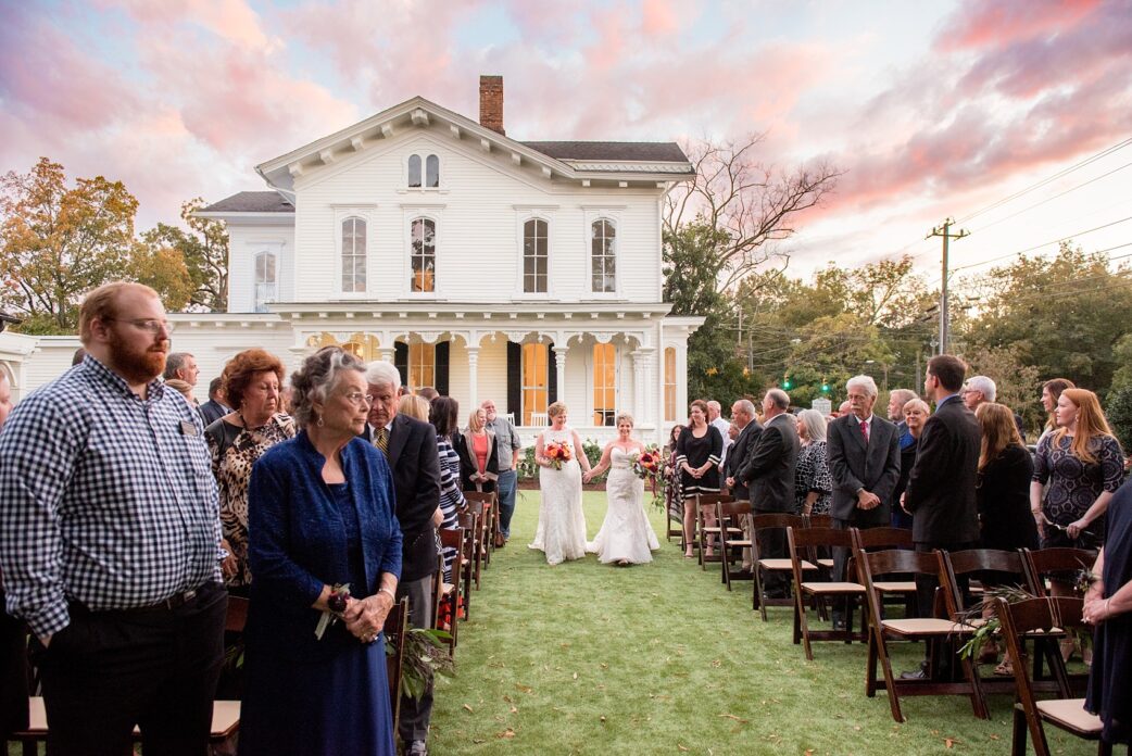 Mikkel Paige Photography photos from a Merrimon-Wynne House wedding in Raleigh. An outdoor sunset at dusk provided cotton candy skies for a same-sex autumn wedding..