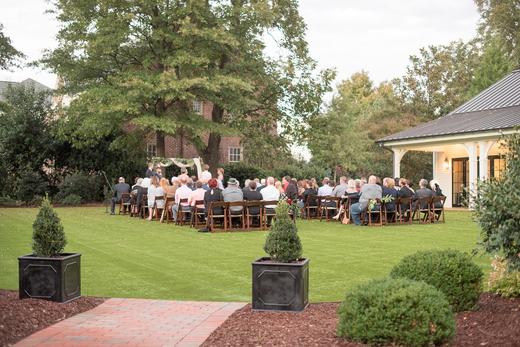 Mikkel Paige Photography photos from a Merrimon-Wynne House wedding in Raleigh. An outdoor sunset at dusk provided cotton candy skies for a same-sex autumn wedding..