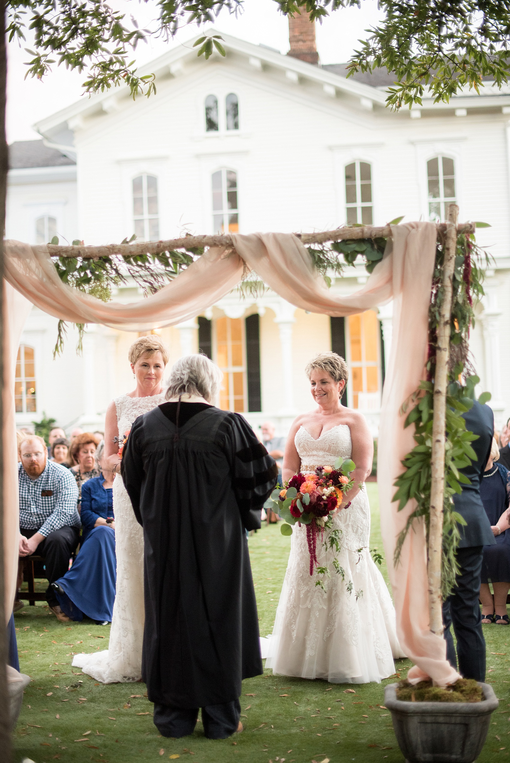 Mikkel Paige Photography photos from a Merrimon-Wynne House wedding in Raleigh. An outdoor sunset at dusk provided cotton candy skies for a same-sex autumn wedding..