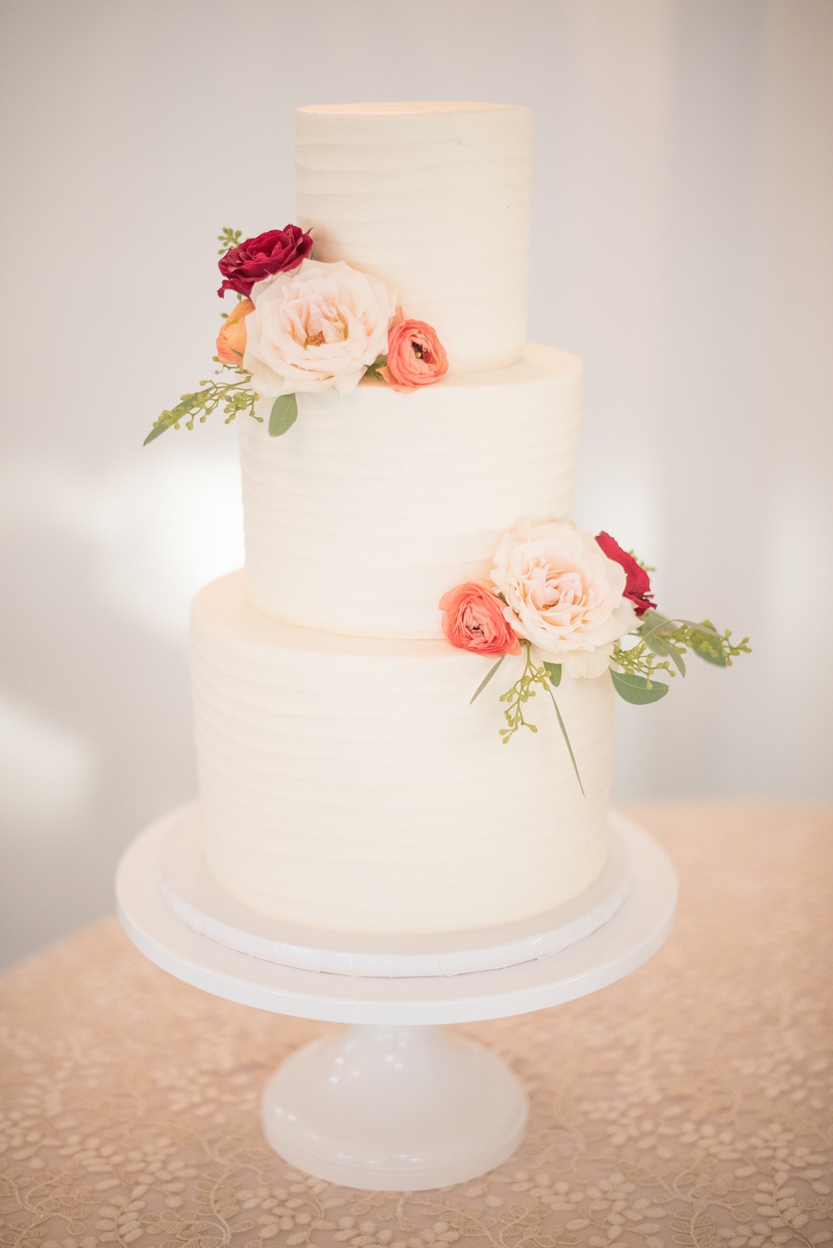 Mikkel Paige Photography photos from a Merrimon-Wynne House wedding in Raleigh. The Cupcake Shoppe created this three tier white buttercream cake adorned with fall flowers from Meristem Floral.