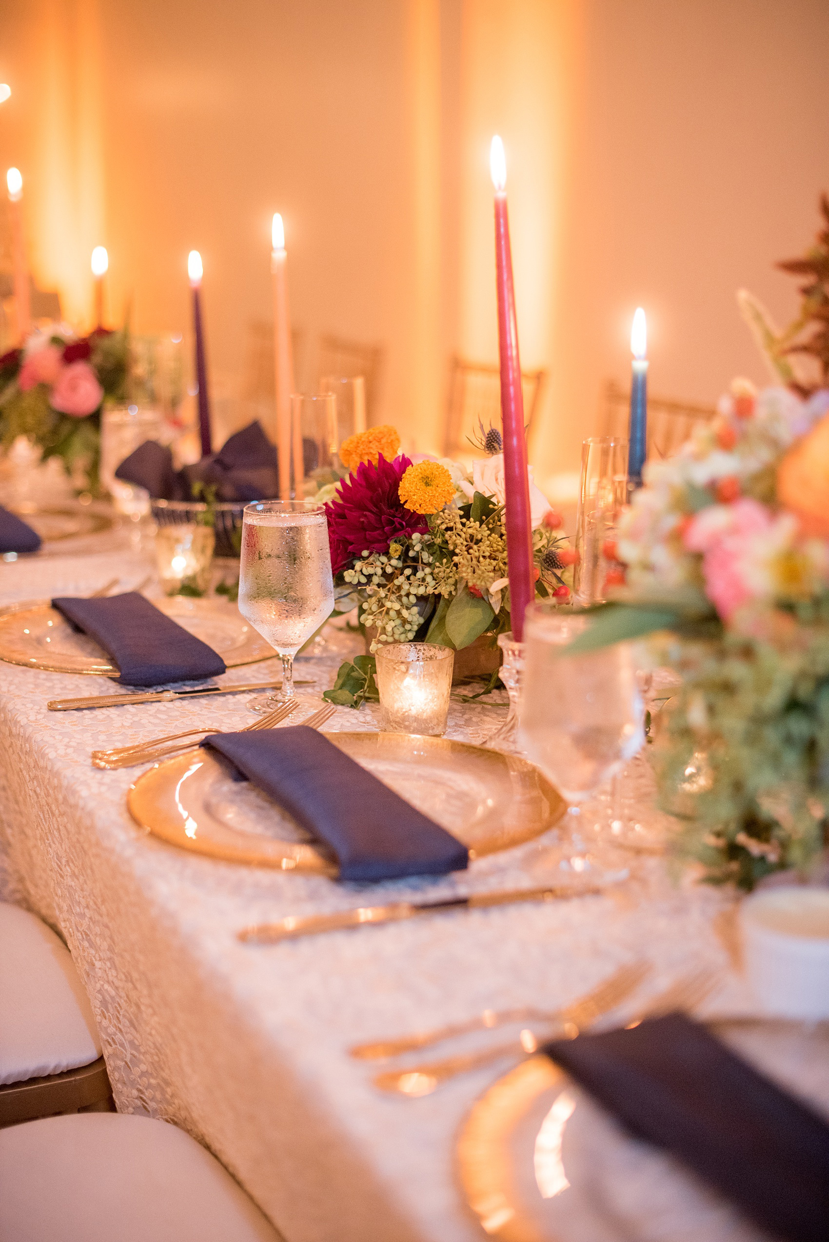 Mikkel Paige Photography photos from a Merrimon-Wynne House wedding in Raleigh. The reception was drenched in romantic candlelight and eucalyptus garland held inside the Carriage House. Glass chargers were in between gold flatware and mercury glass votive holders.