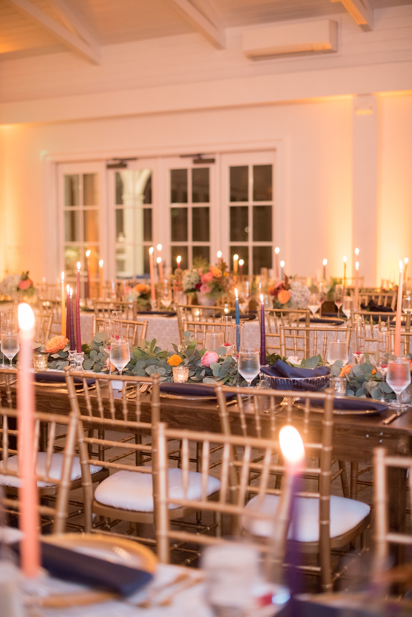Mikkel Paige Photography photos from a Merrimon-Wynne House wedding in Raleigh. The reception was drenched in romantic candlelight and eucalyptus garland held inside the Carriage House. Glass chargers were in between gold flatware and mercury glass votive holders.