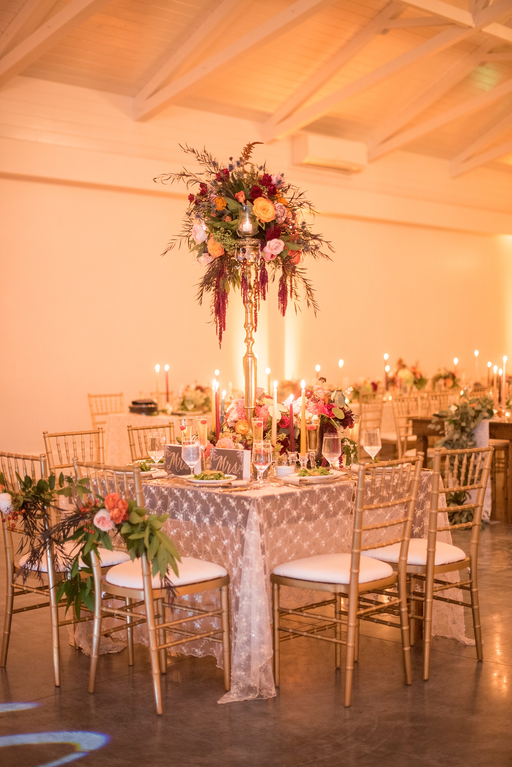 Mikkel Paige Photography photos from a Merrimon-Wynne House wedding in Raleigh. The reception was drenched in romantic candlelight and fall flowers held inside the Carriage House. "Mrs" signs were placed at the sweetheart table for two brides.