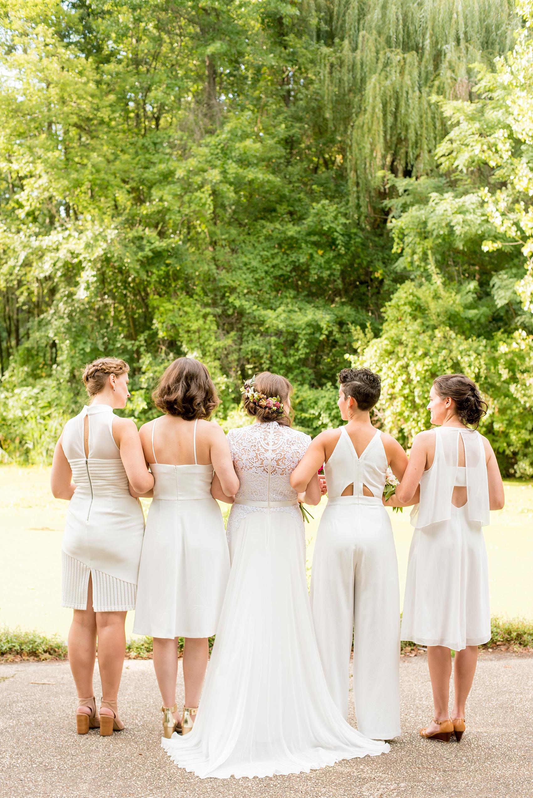Mikkel Paige Photography photos of a wedding at Prospect Park Boathouse in Brooklyn, NY. The bride and her bridesmaids wore different white dresses with unique backs in this candid bridal party picture.