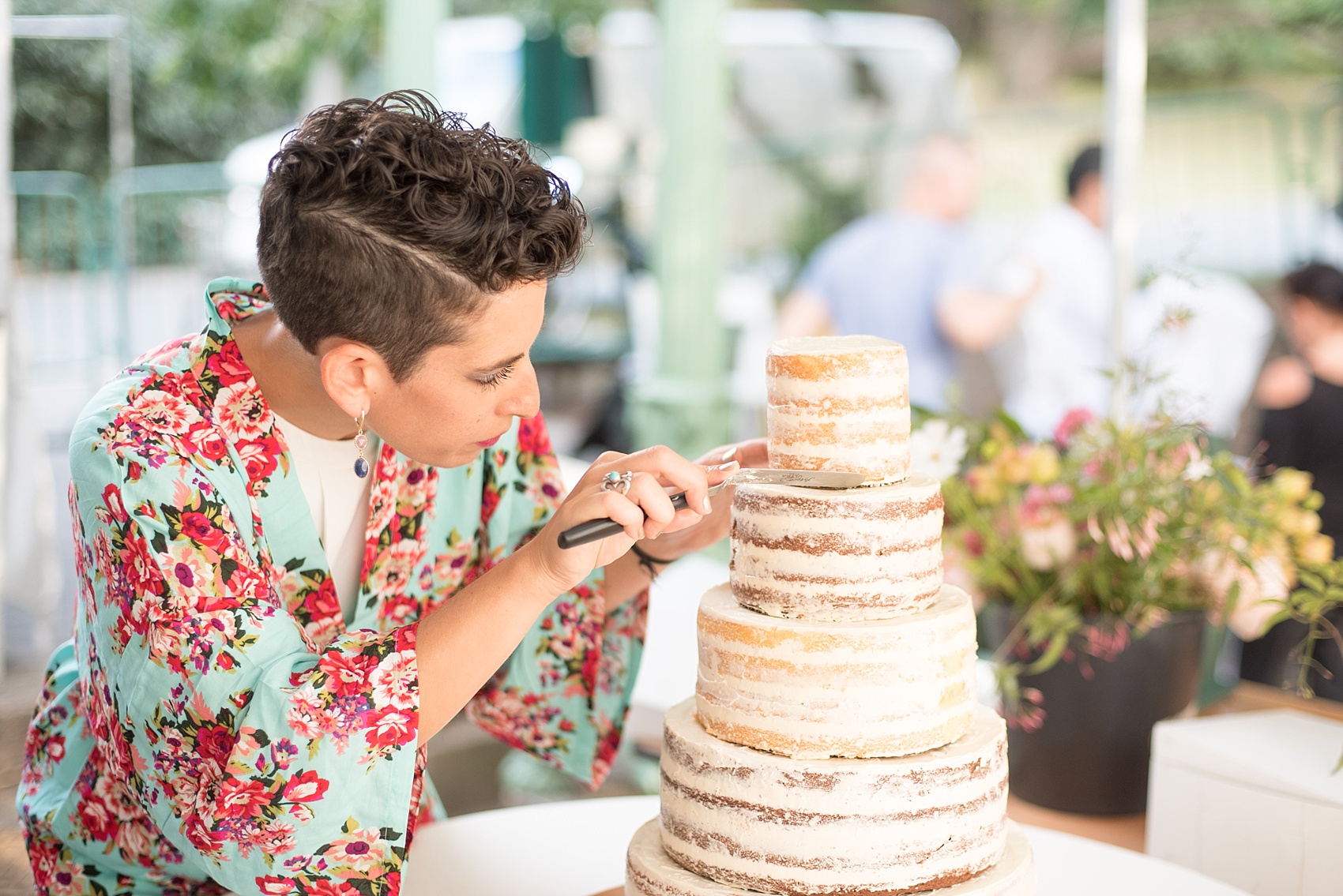 Mikkel Paige Photography photo of a bridesmaid putting the final touches on a naked wedding cake for her friend's day at Prospect Park Boathouse in Brooklyn, NYC.