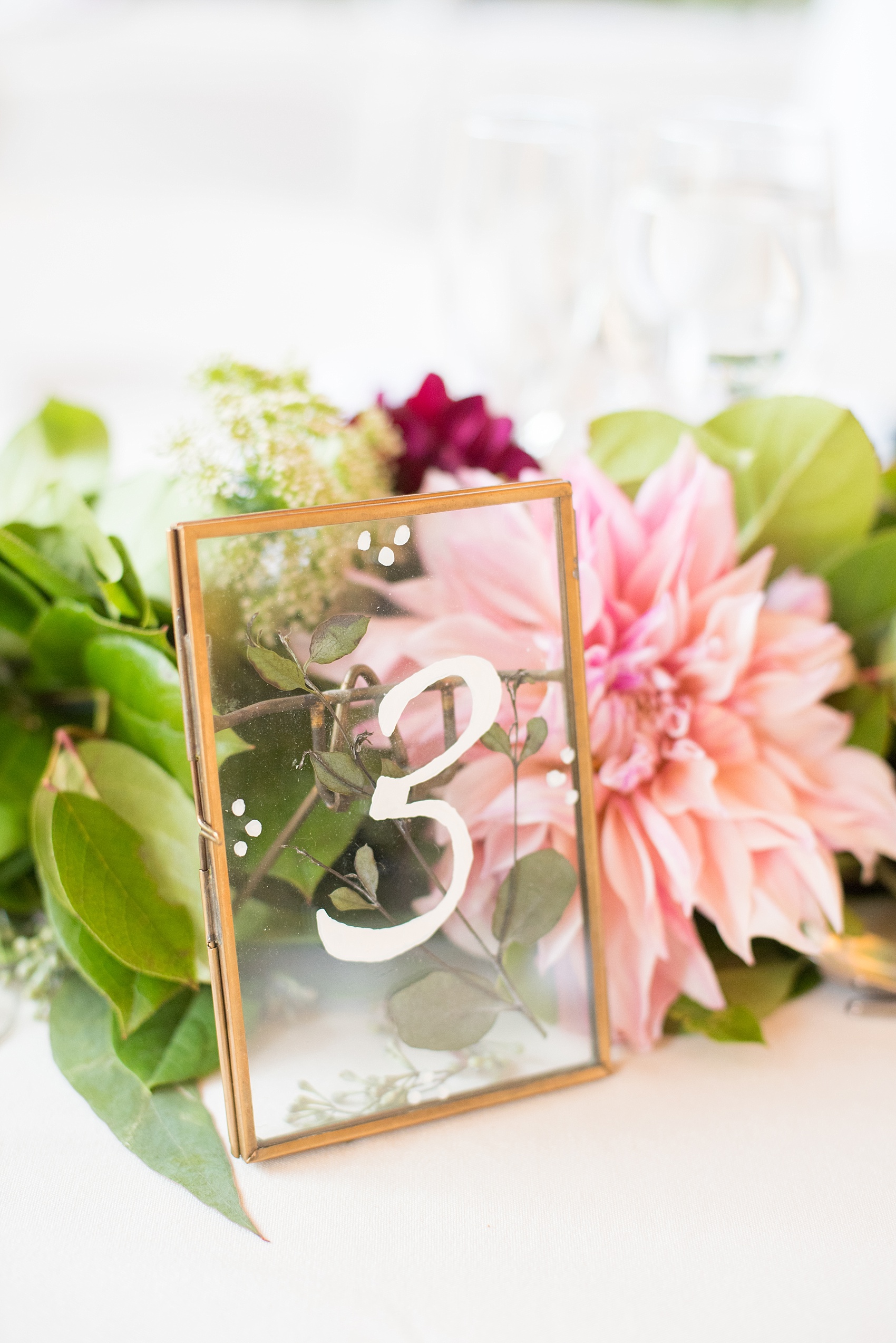 Mikkel Paige Photography photos of a wedding at Brooklyn's Prospect Park Boathouse with a glass framed table number.