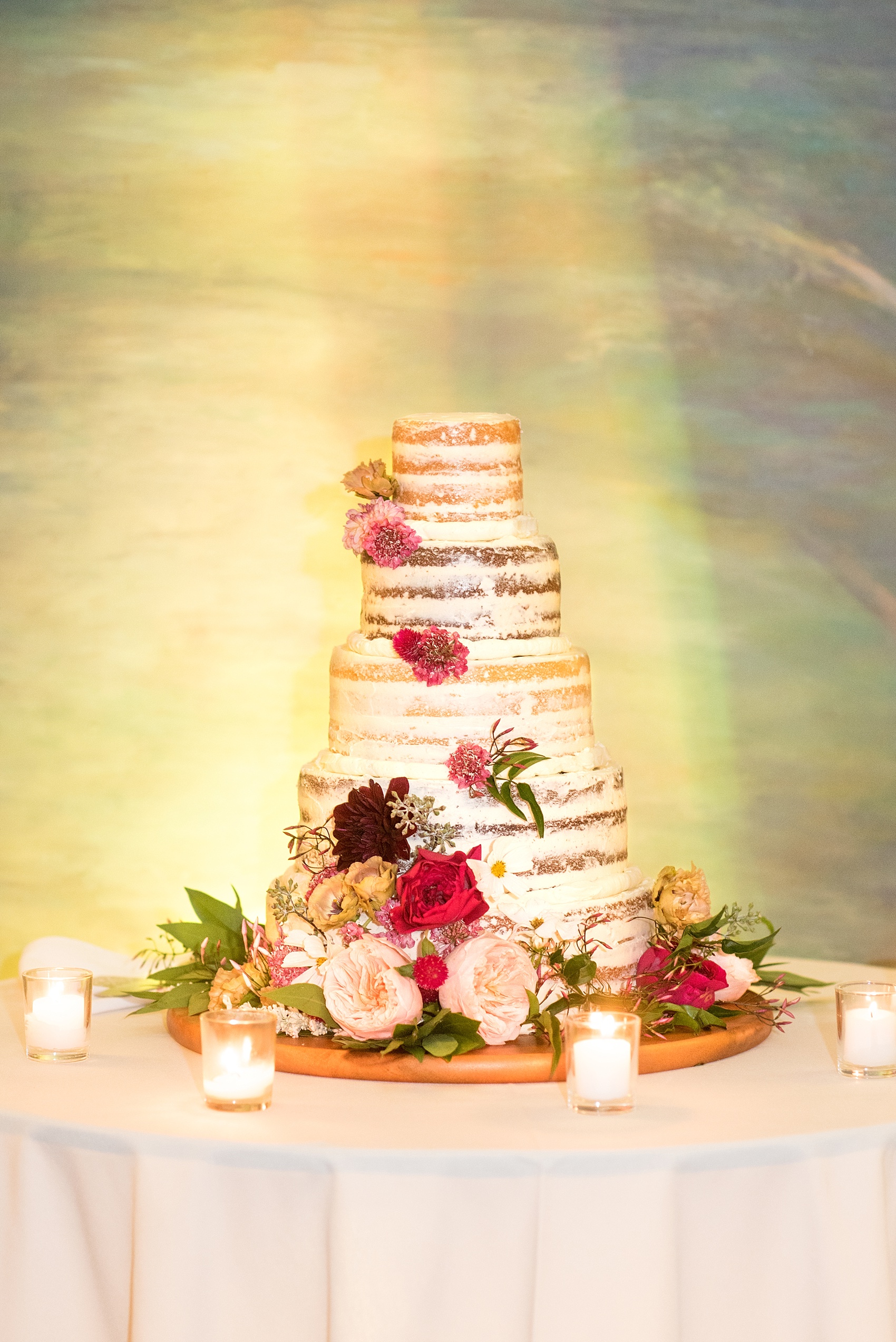 Mikkel Paige Photography photos of a wedding at Brooklyn's Prospect Park Boathouse with a naked tiered cake adorned with pink flowers.