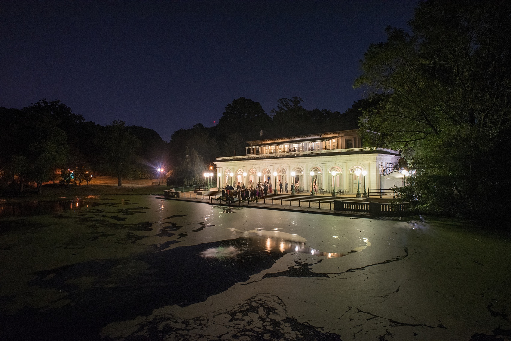 Mikkel Paige Photography photos of a wedding at Brooklyn's Prospect Park Boathouse. A night image of the reception celebration from afar.