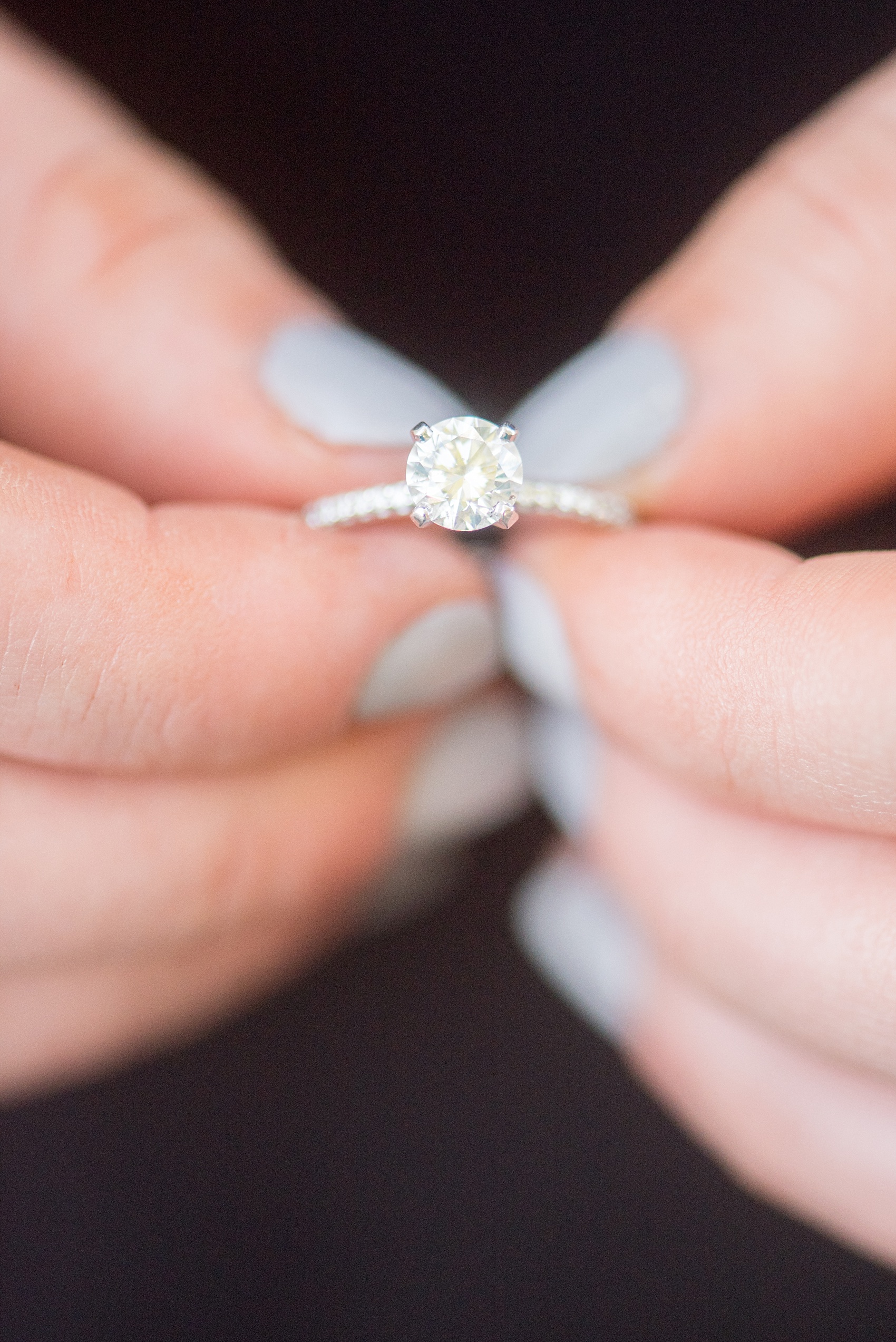 Mikkel Paige Photography photos of a colorful downtown Raleigh engagement session with a round diamond eternity band engagement ring and grey nailpolish. 