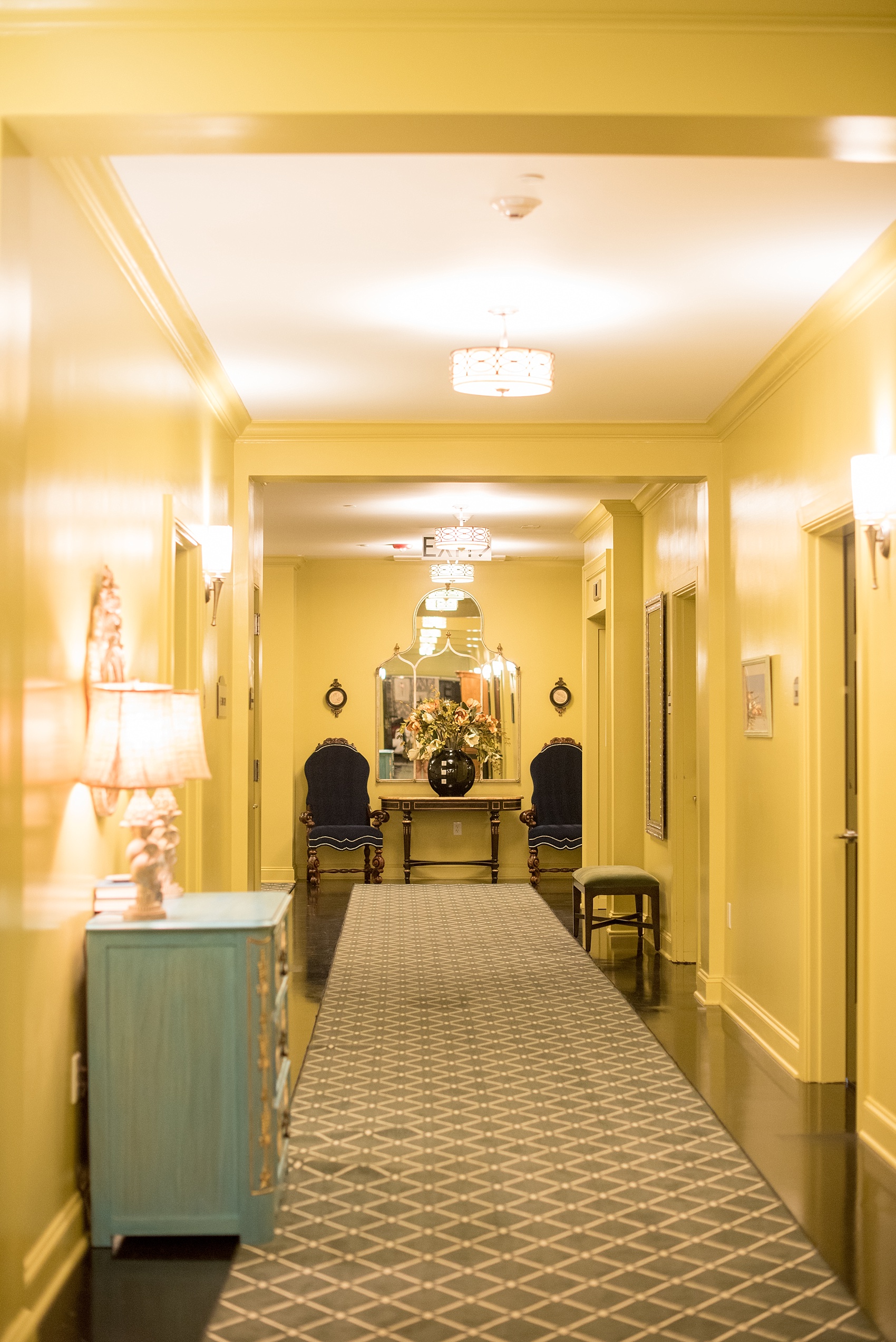 Mikkel Paige Photography, Raleigh wedding photographer, photos of The Mayton Inn hotel and venue in Cary, NC. Yellow hallways with black chairs and blue dresser detail images.