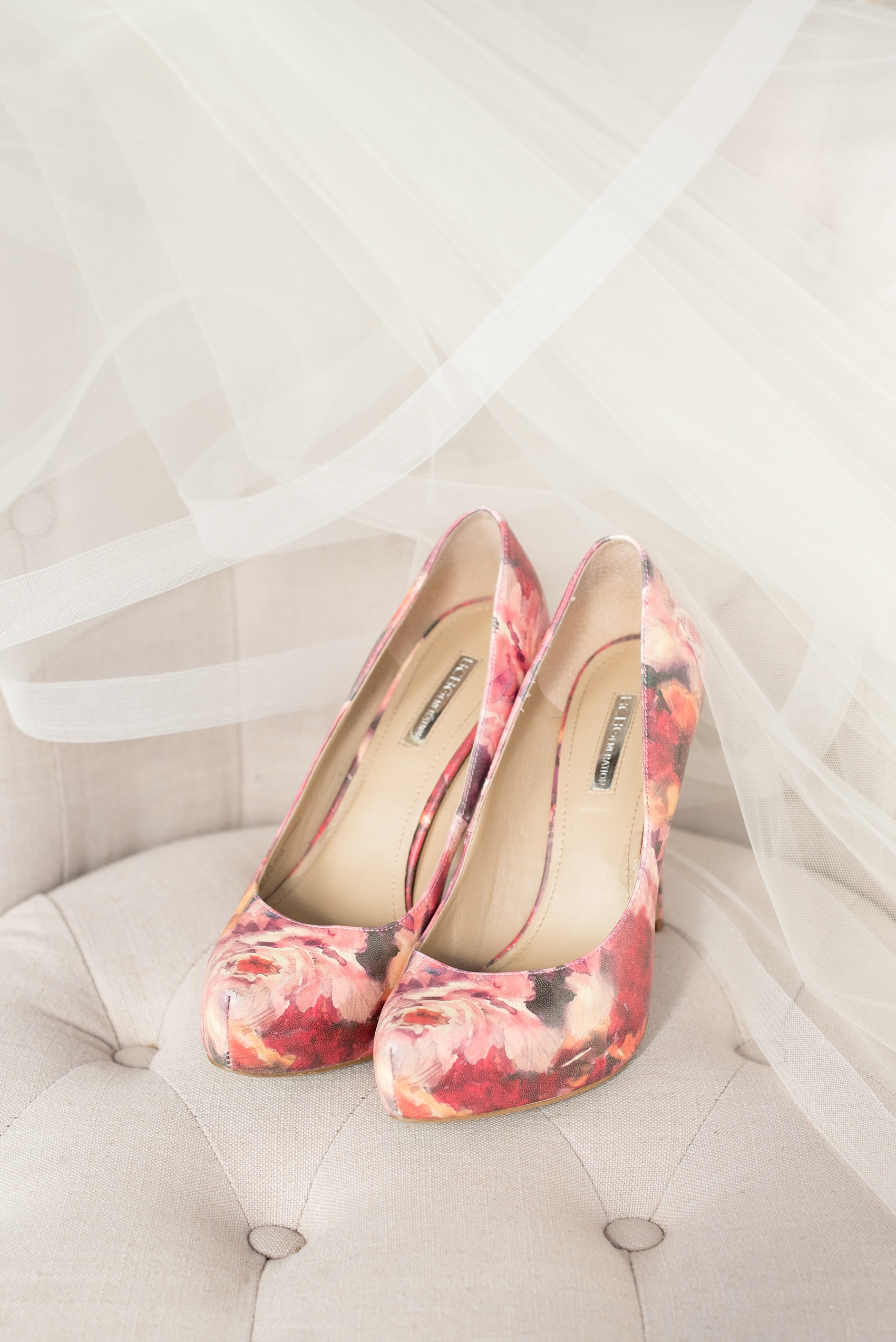 Mikkel Paige Photography photo of a wedding at The Rickhouse, Durham. This image of the bride's shoes and veil show her unique personality - pink and red floral pattern heels for the day!