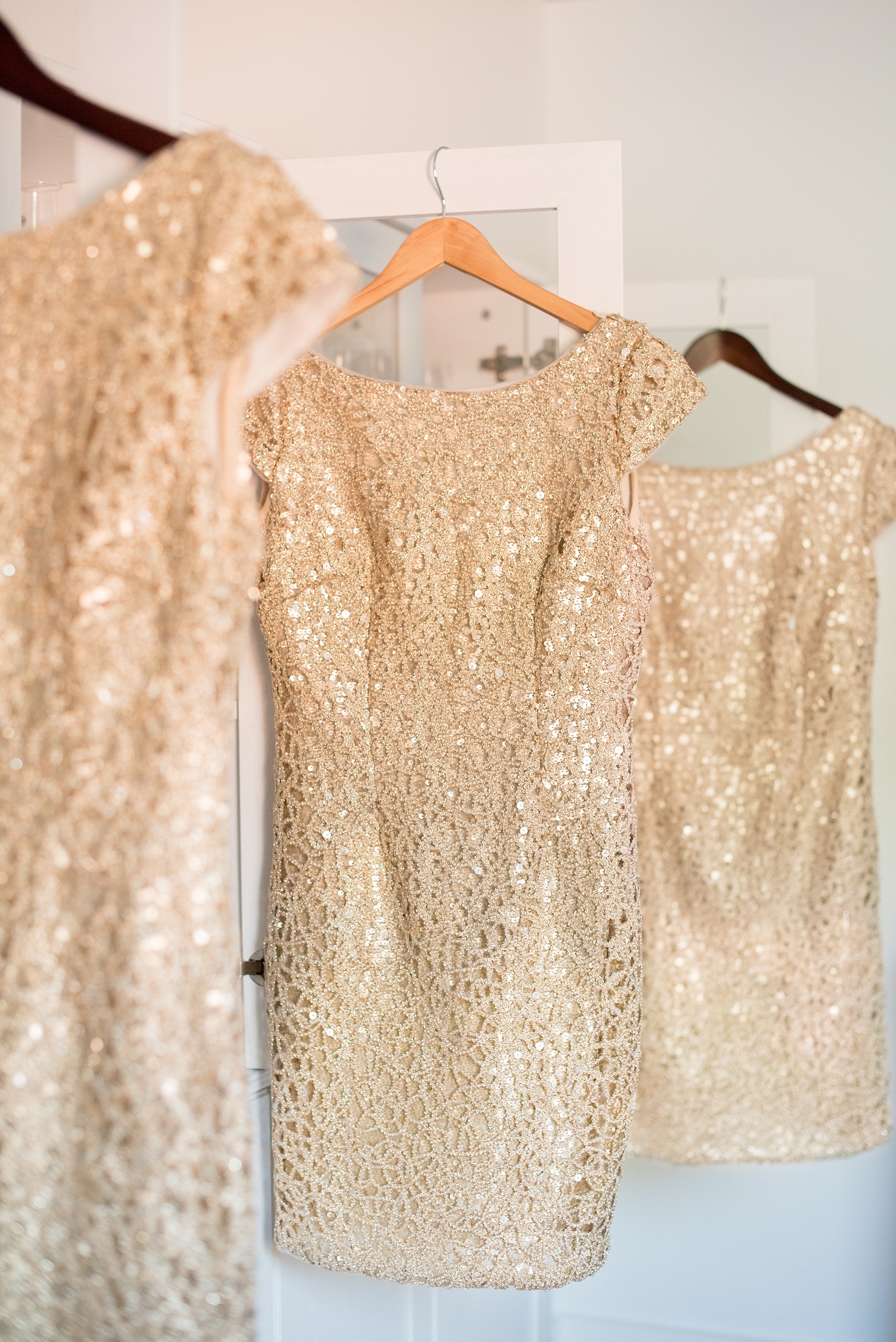 Mikkel Paige Photography detail photo of short gold Adrianna Papell bridesmaids dresses for a 214 Martin Street downtown Raleigh wedding.