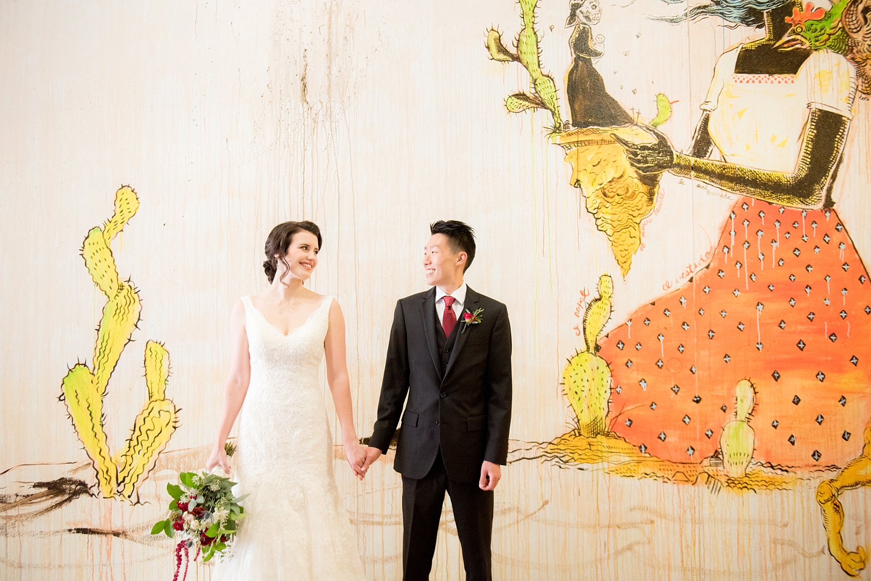 Mikkel Paige Photography photo of bride and groom in downtown Raleigh for a 214 Martin Street wedding. Graffiti wall near Artspace for a portrait background.