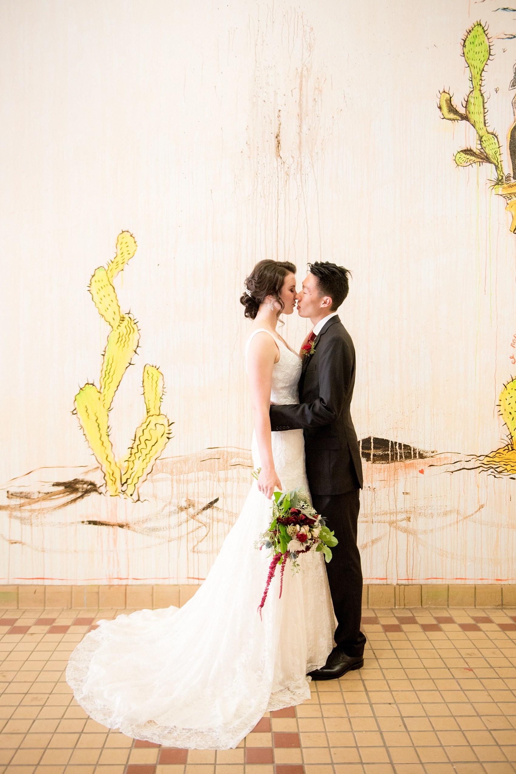 Mikkel Paige Photography photo of bride and groom in downtown Raleigh for a 214 Martin Street wedding. Graffiti wall near Artspace for a portrait background.