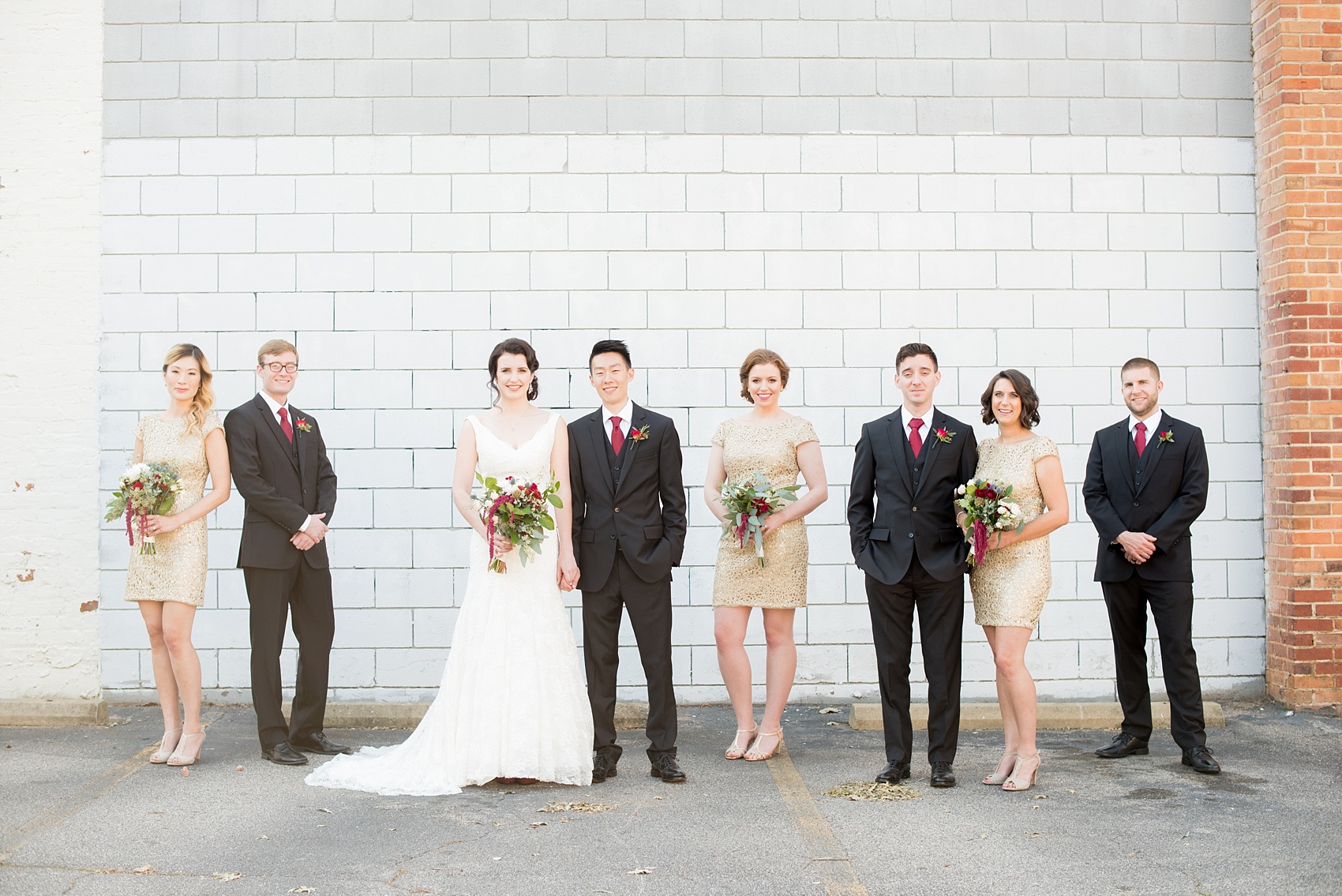 Mikkel Paige Photography photo of a bridal party in gold short dresses and groomsmen with red ties for a fall wedding at 214 Martin Street in downtown Raleigh.