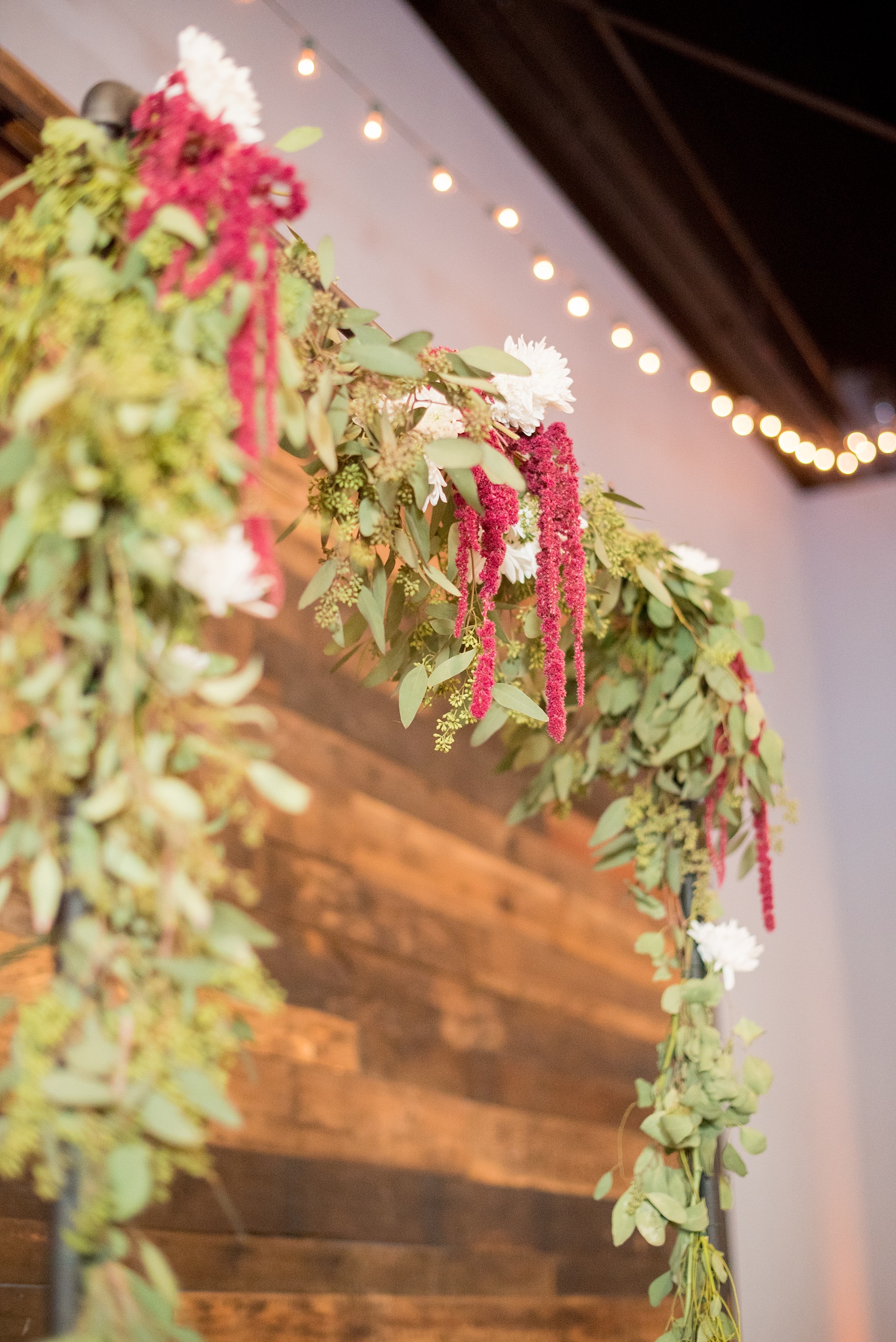 Mikkel Paige Photography photos from a wedding at 214 Martin Street in downtown Raleigh with a fall flower arbor for an indoor ceremony.