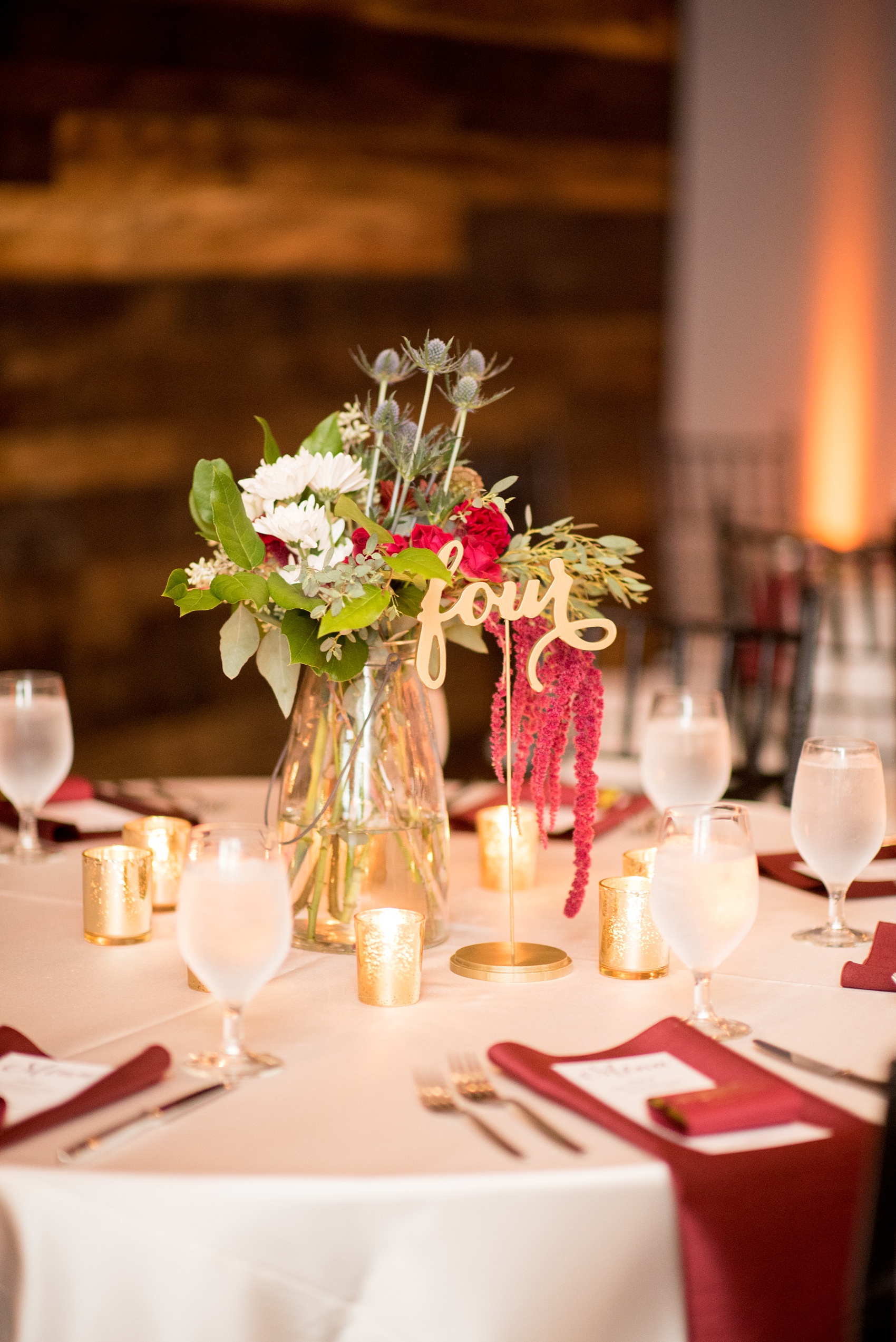 Mikkel Paige Photography photos from a wedding at 214 Martin Street in downtown Raleigh with fall flowers and bistro market lights. Gold painted script wood words served as table numbers.