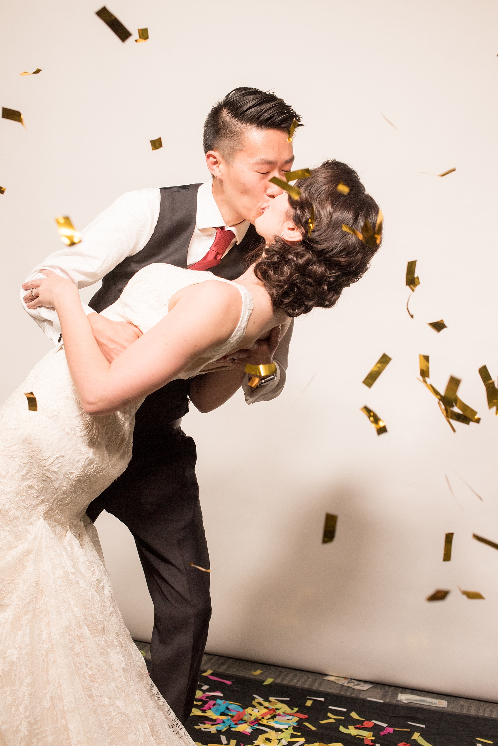 Mikkel Paige Photography photos from a wedding at 214 Martin Street in downtown Raleigh. Slo-motion booth with the bride and groom kissing with metallic confetti.