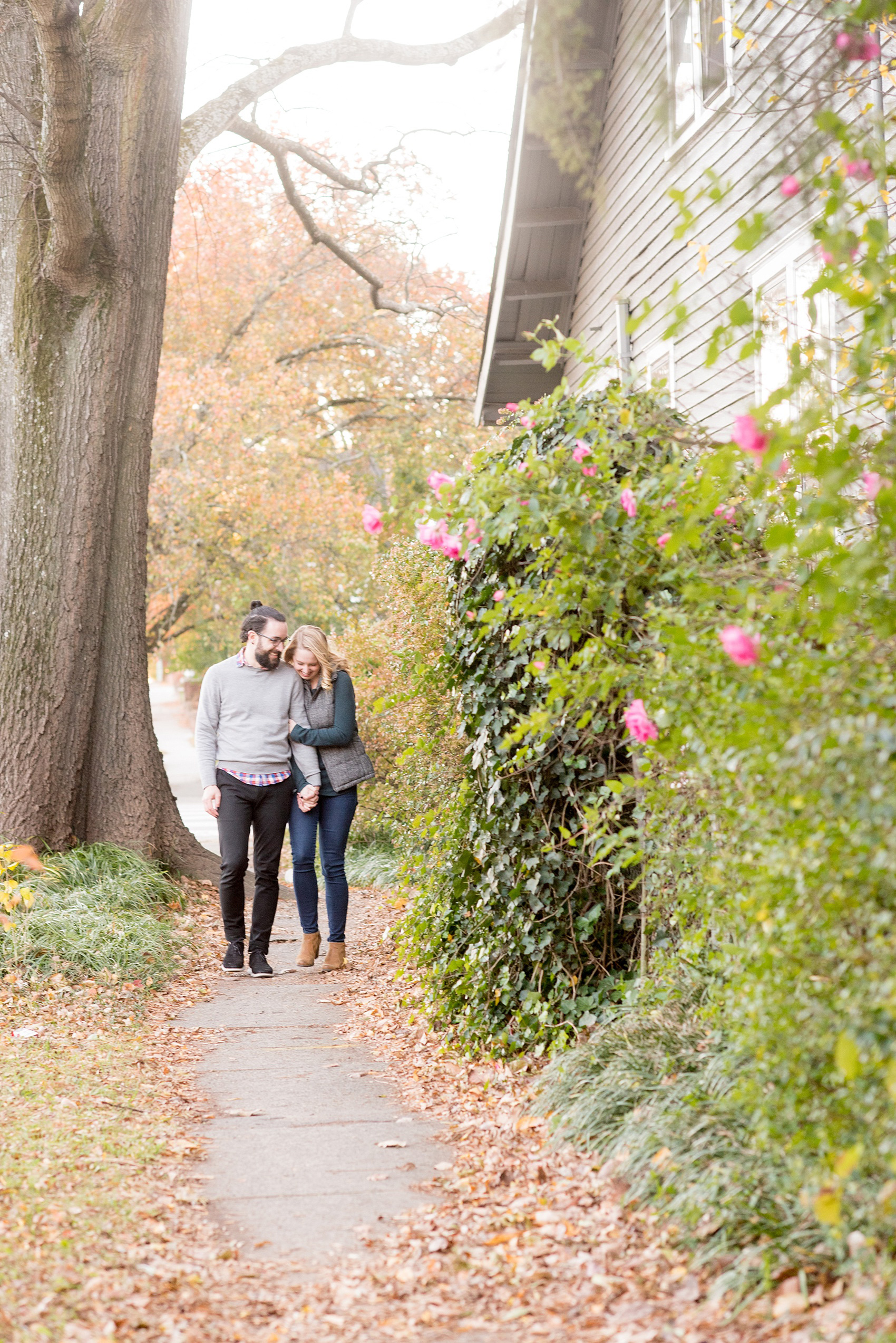 Mikkel Paige Photography photos of a downtown Durham engagement session amidst fall colors and pink rose bushes.