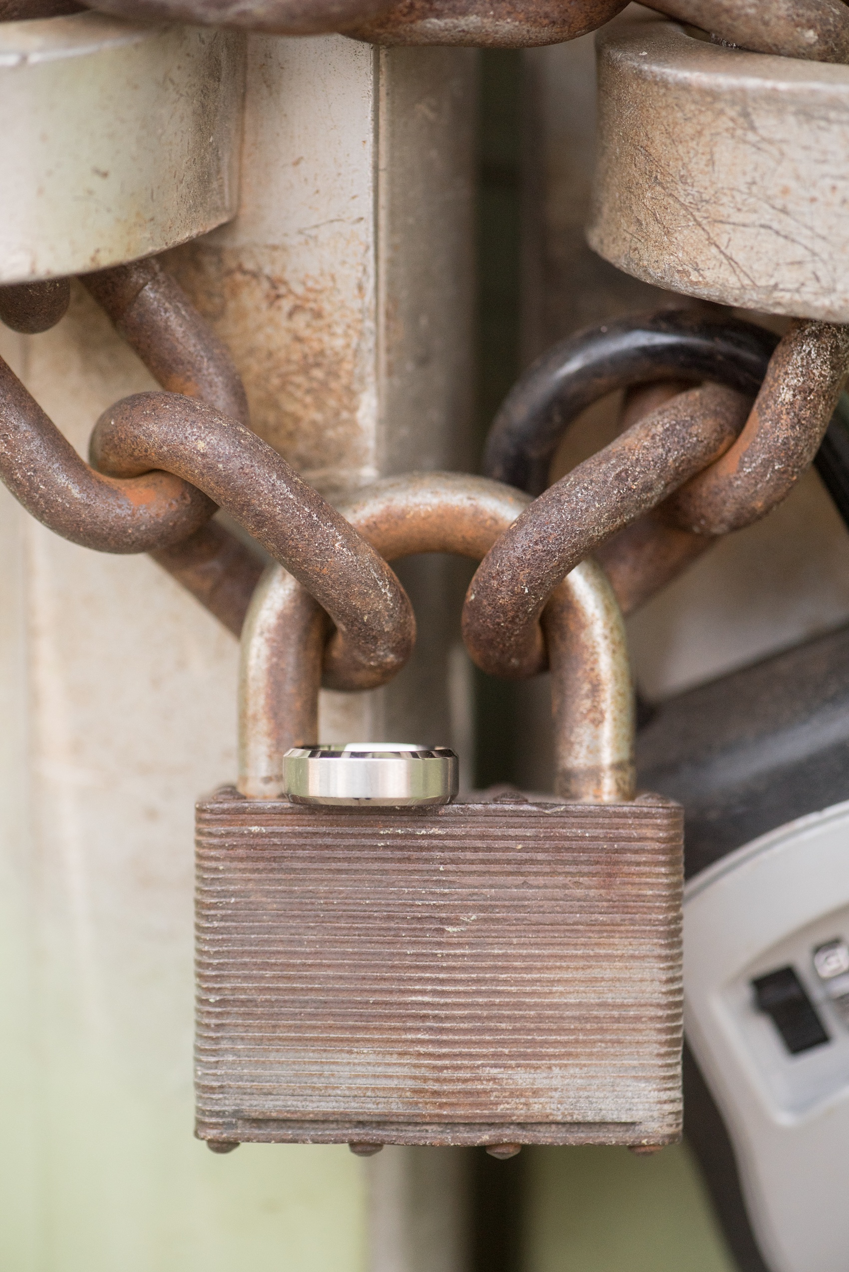 Mikkel Paige Photography photos of a downtown Durham engagement session. A picture of the groom's engagement ring on a rusting lock.