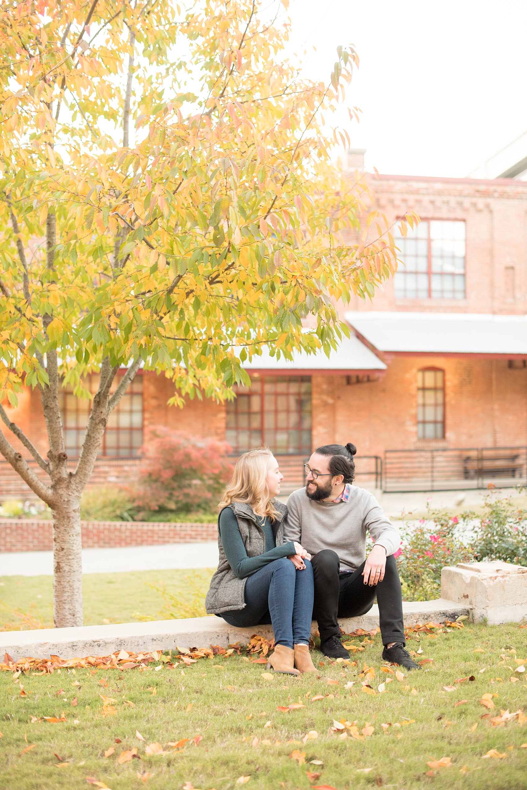 Mikkel Paige Photography photos of a Durham engagement session at American Tobacco Campus with fall leaves.