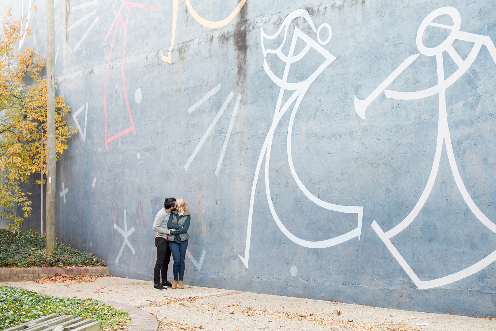 Mikkel Paige Photography photos of a Durham engagement session in downtown Durham against a musical mural.