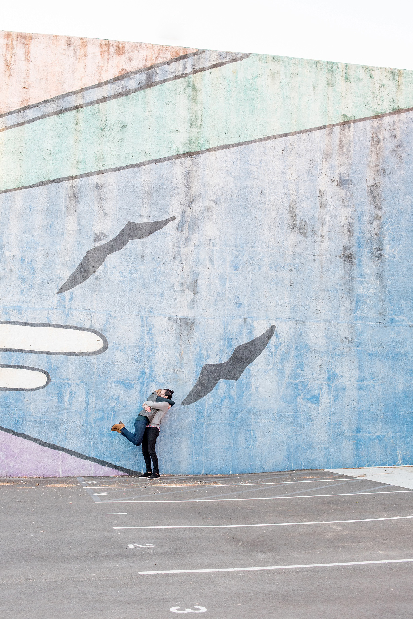 Mikkel Paige Photography photos of a Durham engagement session in downtown Durham against a colorful sun mural.