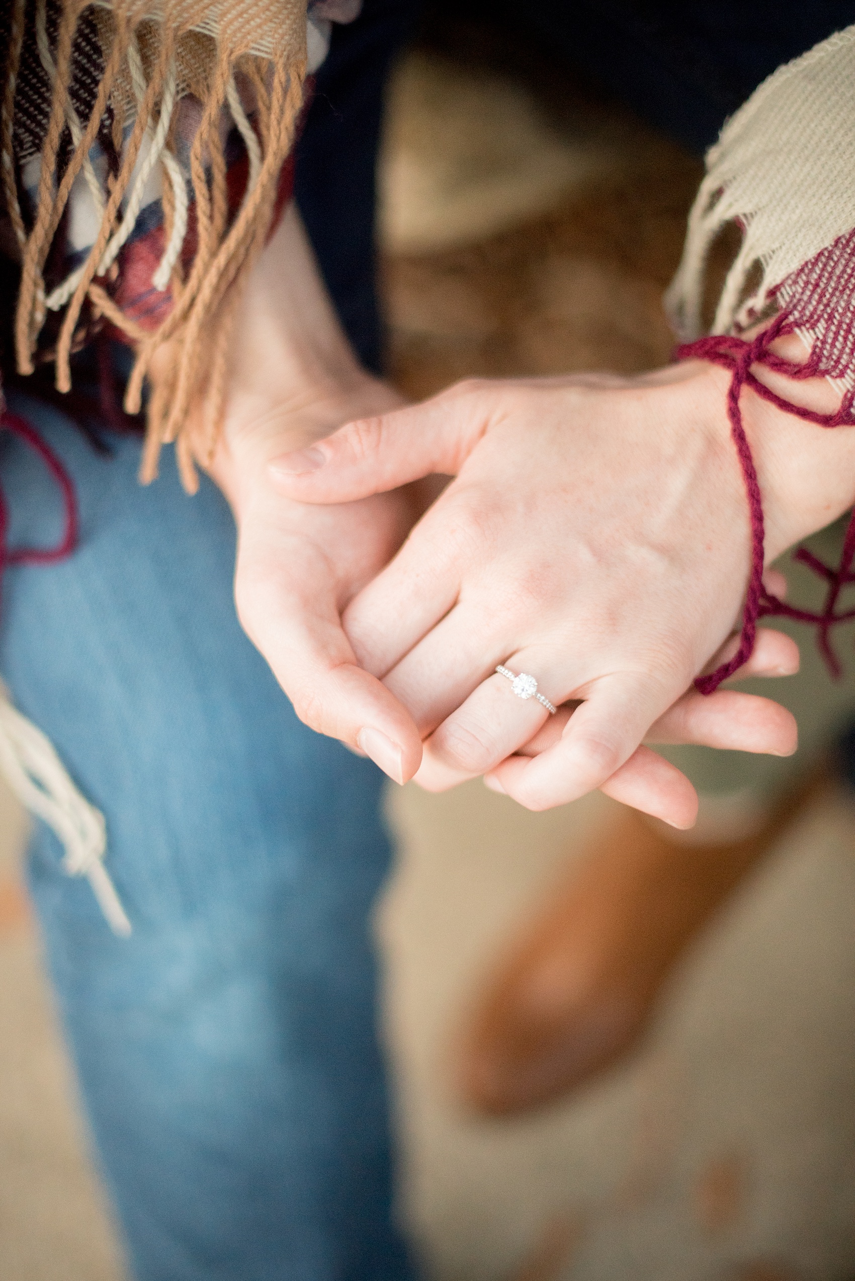 Mikkel Paige Photography photos of a Raleigh engagement session at Pullen Park. The bride and groom got cozy in a burgundy plaid blanket. Detail image of the bride's diamond ring.