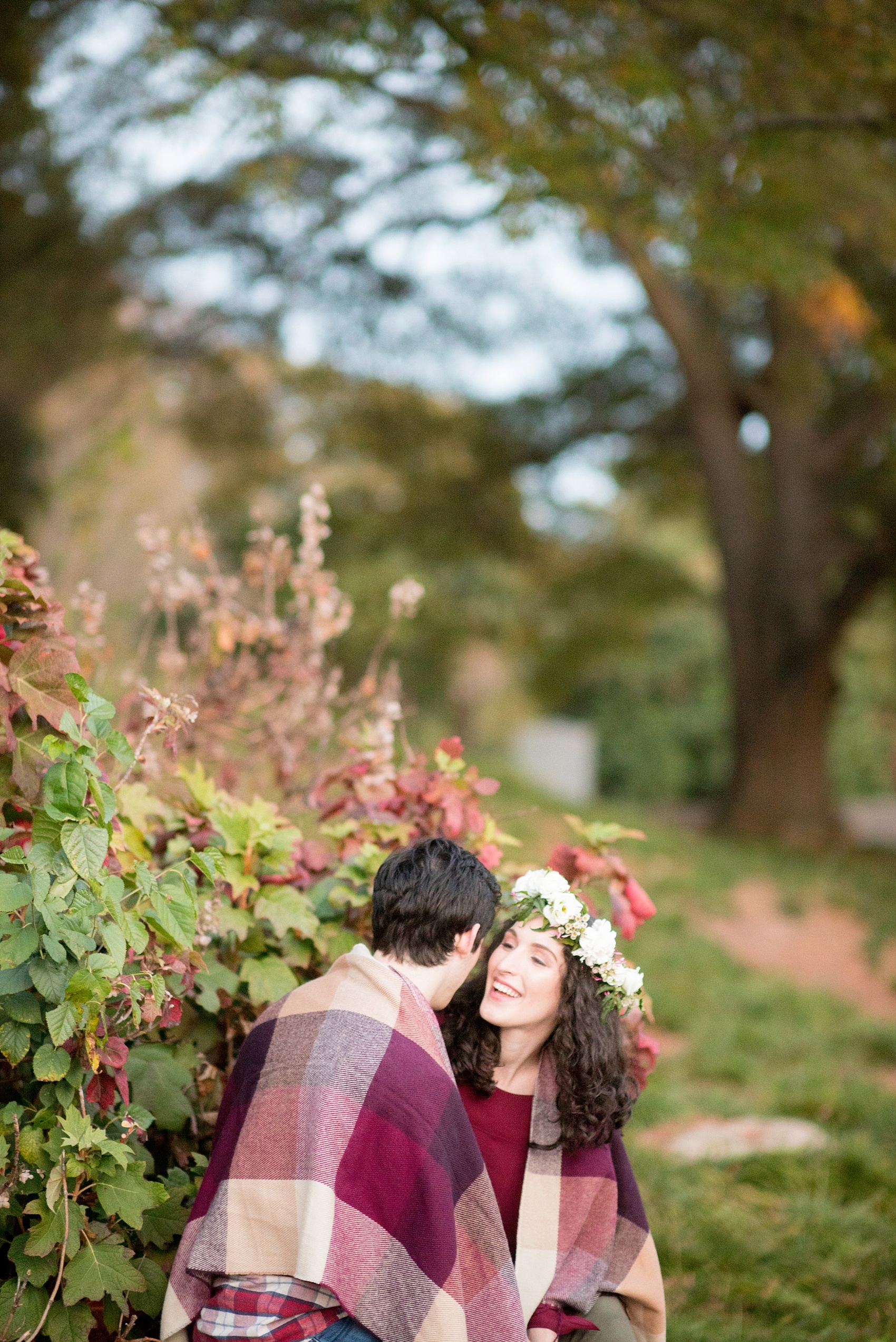 Mikkel Paige Photography photos of a Raleigh engagement session at Pullen Park. The bride and groom got cozy in a burgundy plaid blanket.