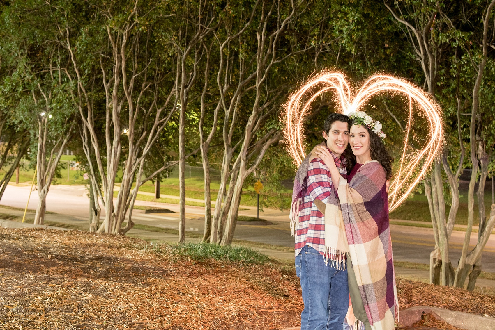 Mikkel Paige Photography photos of a Raleigh engagement session at Pullen Park. A night picture of the bride and groom with a sparkler heart.