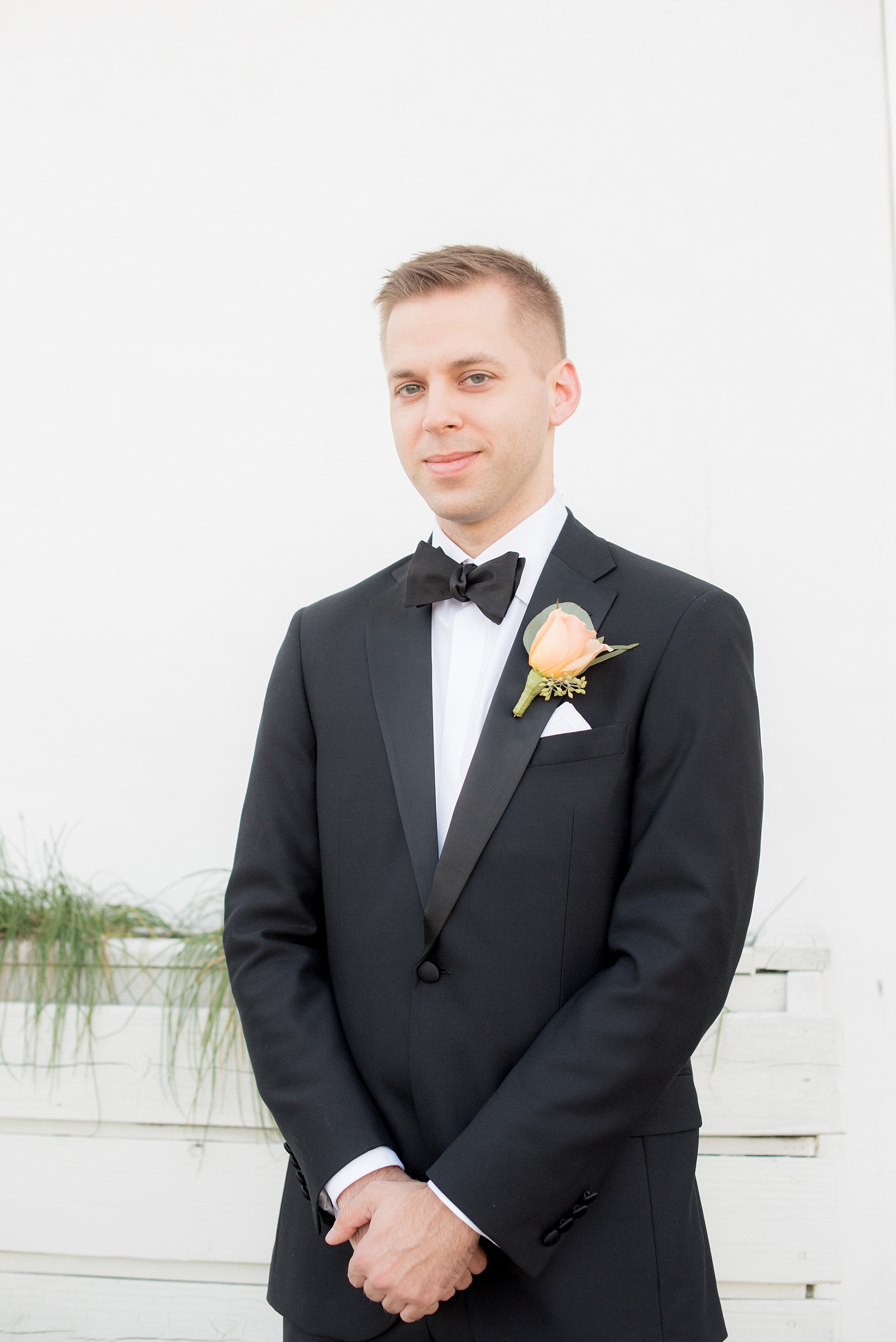 Mikkel Paige Photography photo of a wedding at The Rickhouse, Durham. The groom wore a classic black tuxedo and peach rose boutonniere.